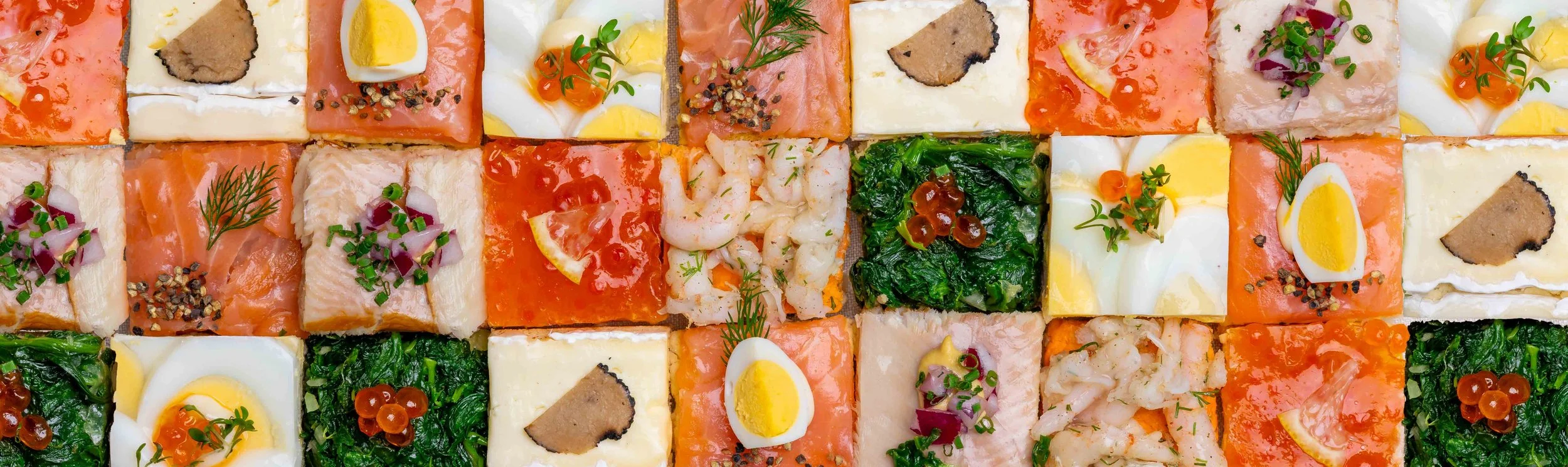 Verschiedene belegte Brotscheiben und Canapés mit Fisch, Ei, Gemüse und Kräutern