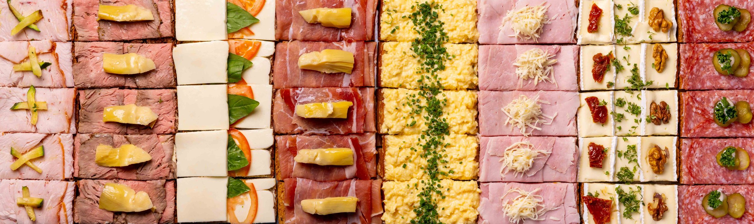 Verschiedene belegte Canapés und Chips auf einem Buffet-Teller