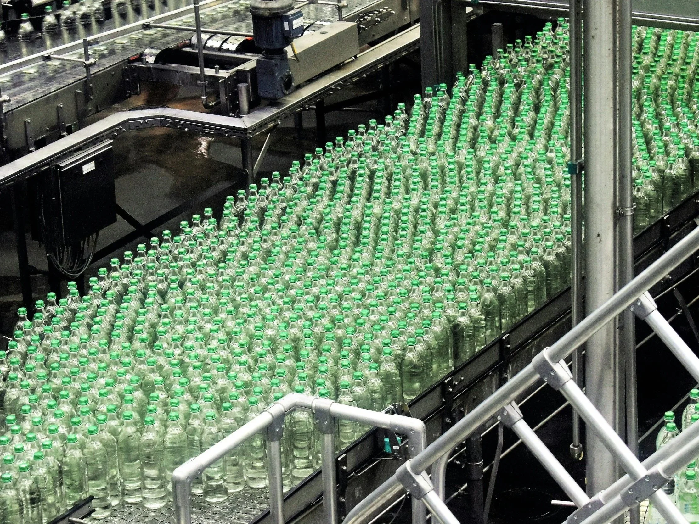 Bottles of water moving along a production line inside a water bottling factory.