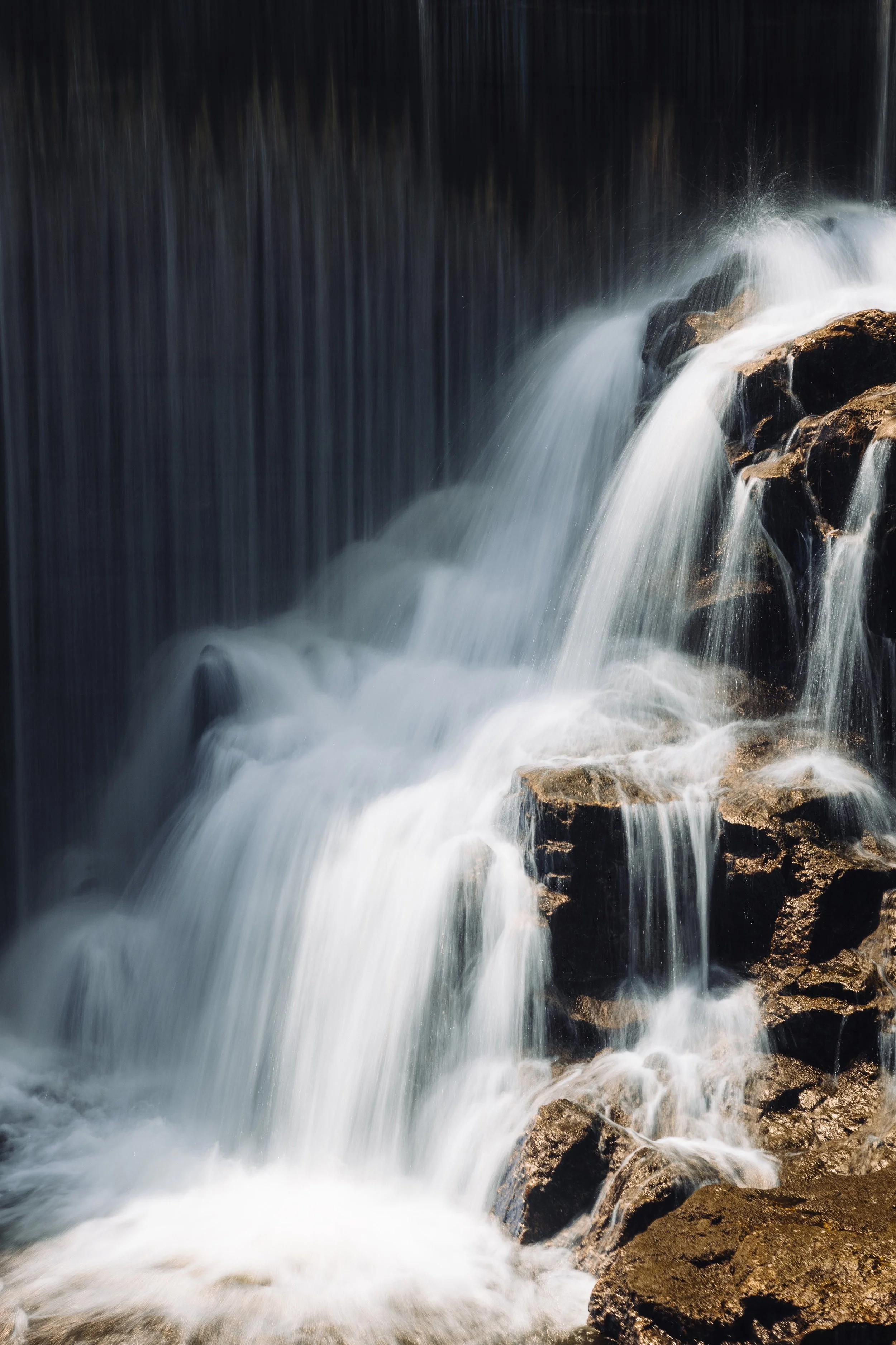Fast-moving water cascading over rocks in a waterfall or stream.