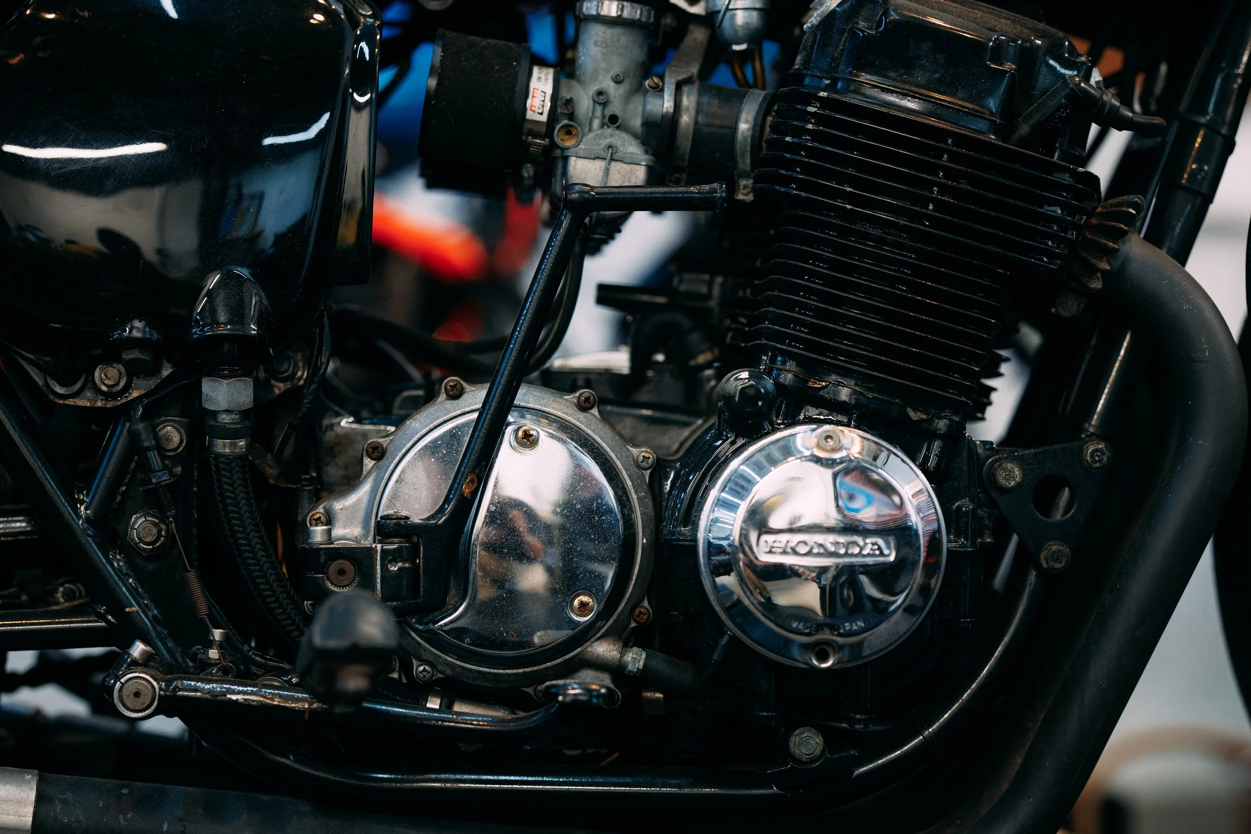 Close-up of a motorcycle engine with black cooling fins and metal components.