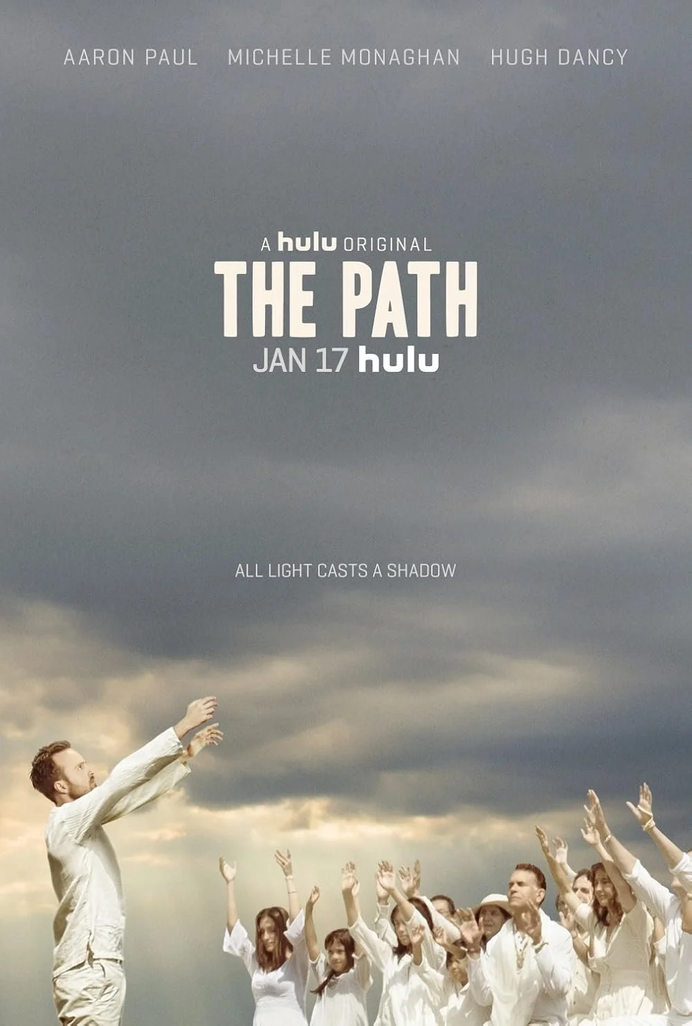 The promotional poster for the Hulu original series 'The Path' features a man and a group of people dressed in white, raising their hands towards a cloudy sky.