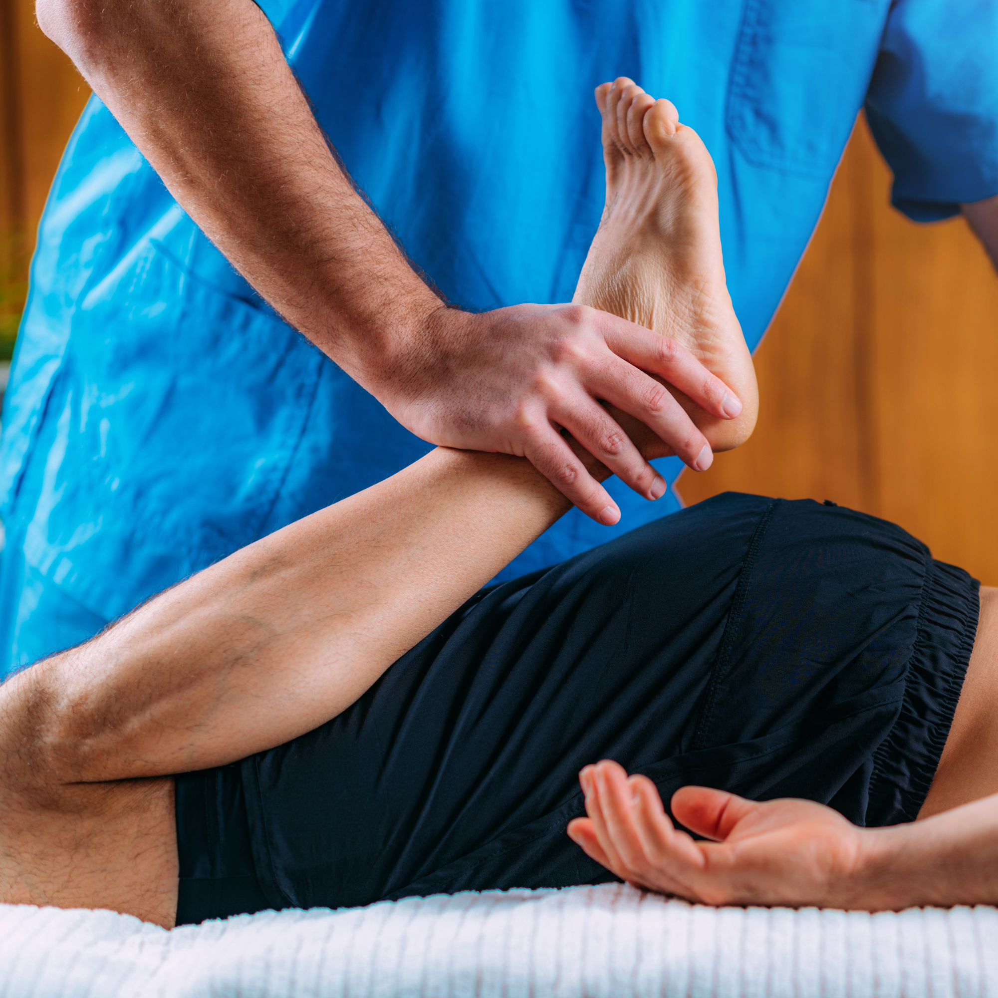 A person receiving a massage in a spa or wellness setting, with another person's hands on their lower back.