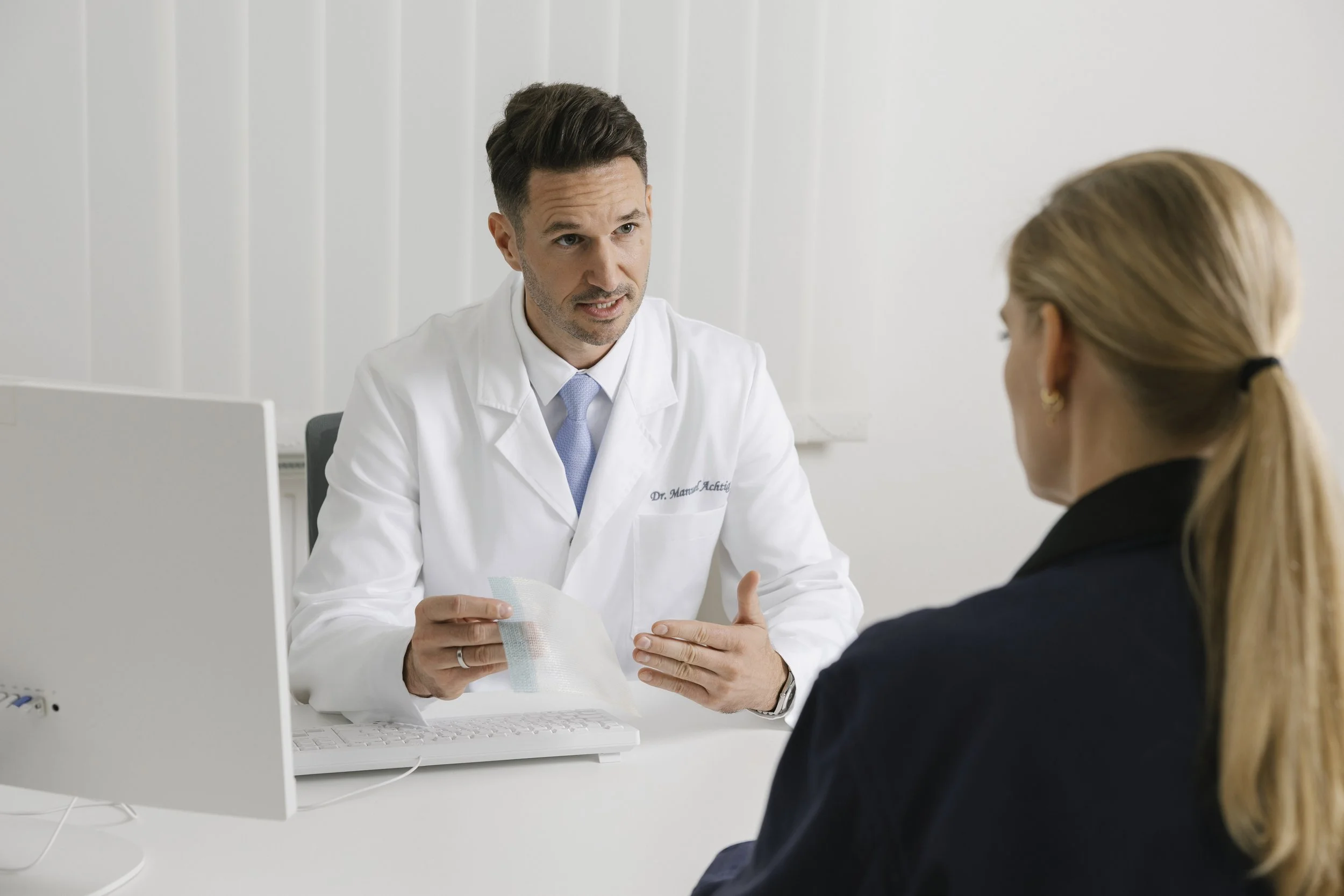 OA Dr. Manuel Achtig im Beratungsgespräch mit einer Patientin in seiner Chirurgie-Ordination in Wien