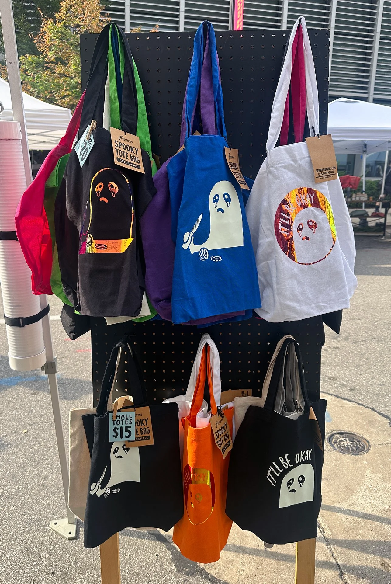 Image of tote bag display with crying ghosts on the bag, designed by Jenny Hearns.