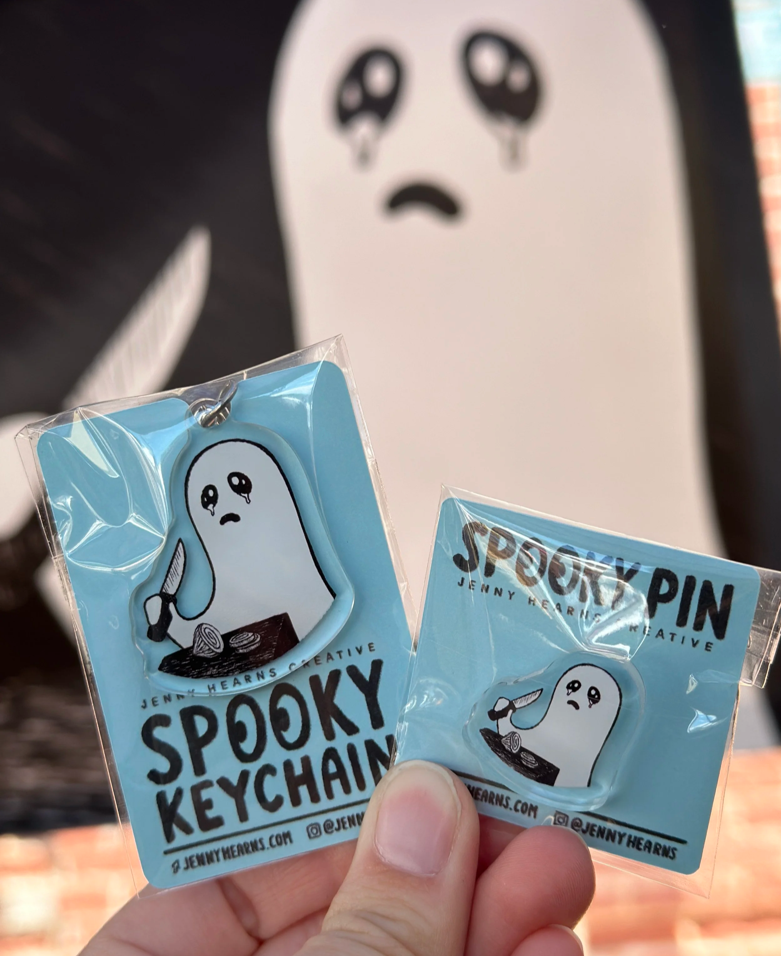 Image of a sad ghost keychain and pin by Jenny Hearns.