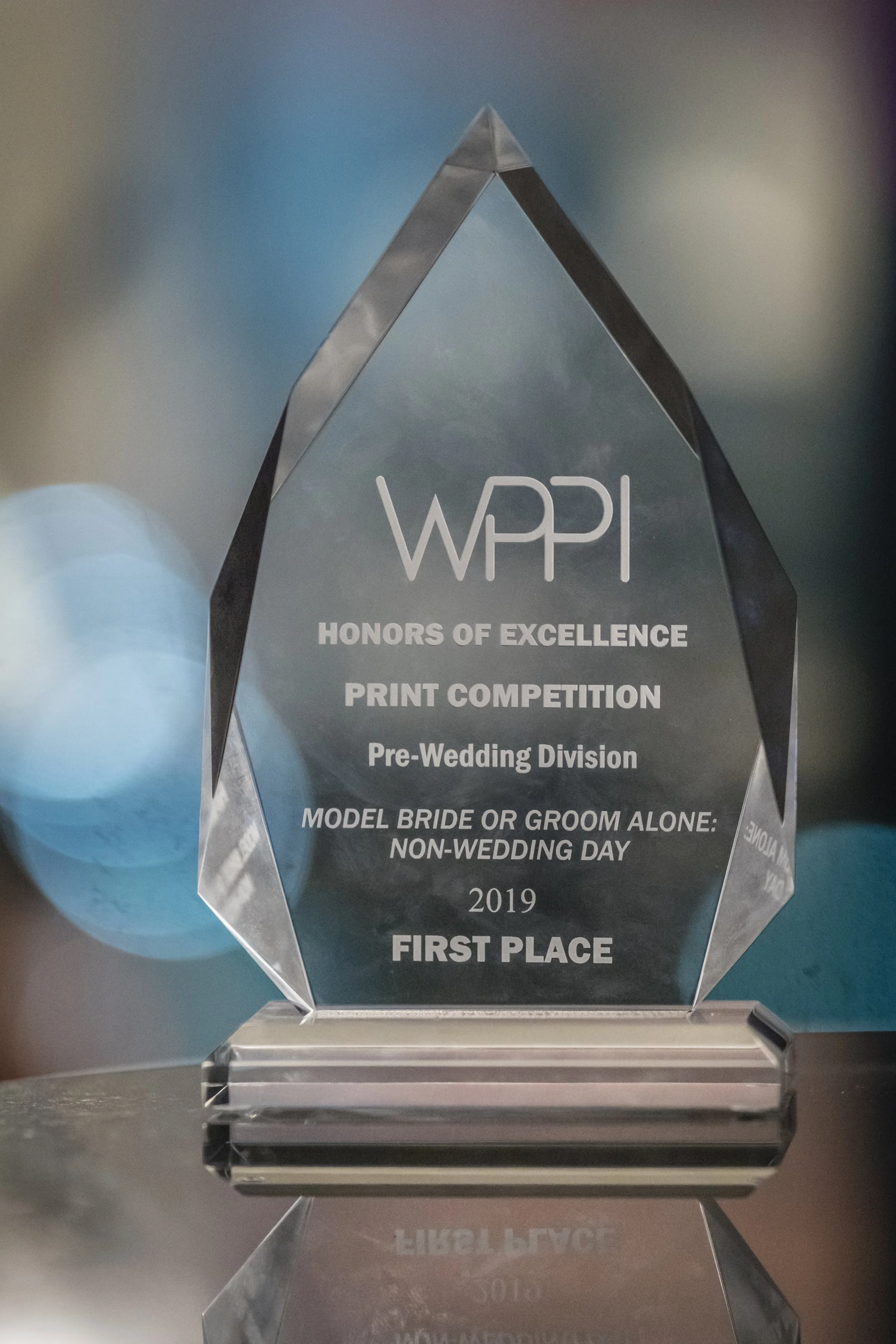 A crystal award trophy with engraved text for the WPPI Honors of Excellence Print Competition, Pre-Wedding Division, Non-Wedding Day category, first place in 2019.