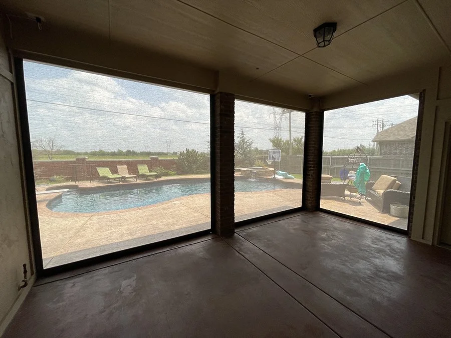 View of a backyard pool area through screened windows, with lounge chairs and outdoor seating.