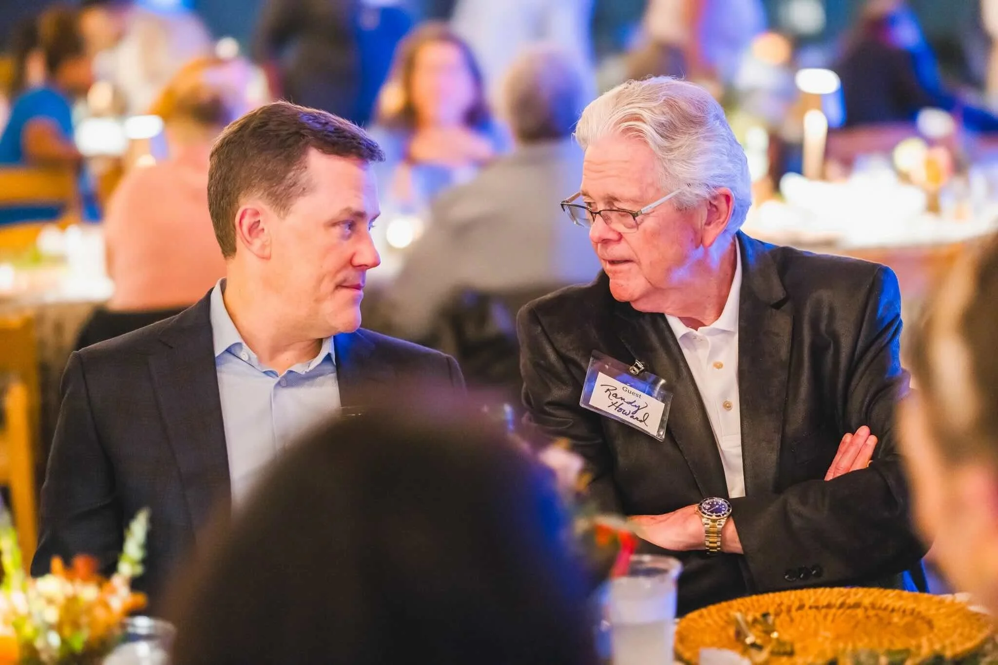 Two men talking at CFM's Friendsgiving event. 