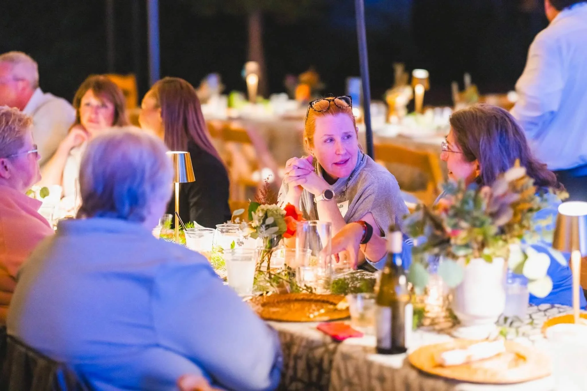 People sitting at a decorated dinner table during an CFM's Friendsgiving event.