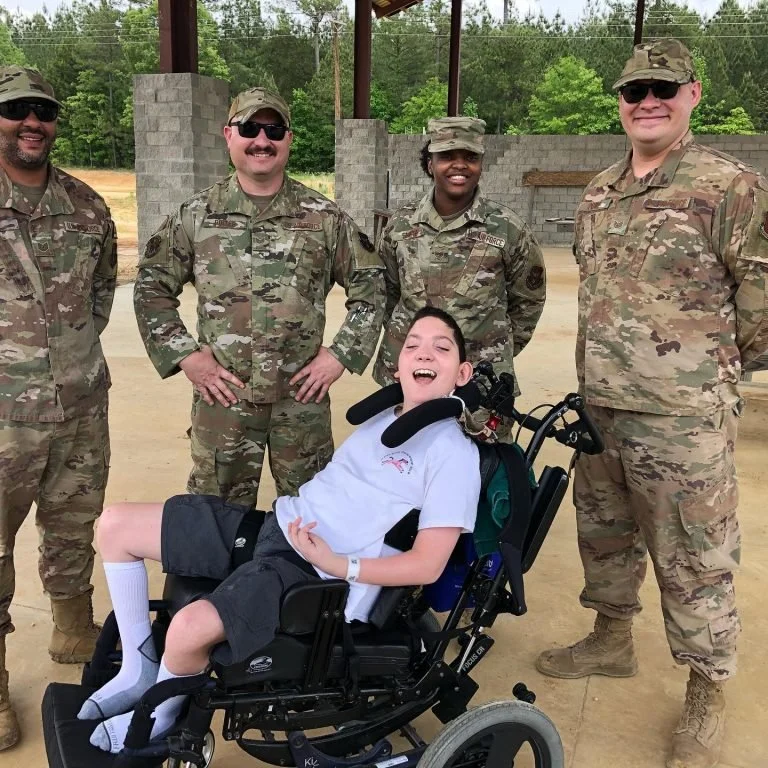 Future camper Nicholas visits with members of the 307th Civil Engineer Squadron out of Barksdale, LA Air Force base while they assist with the construction of the camp as part of the U.S. Department of Defense’s Innovative Readiness Training Program.