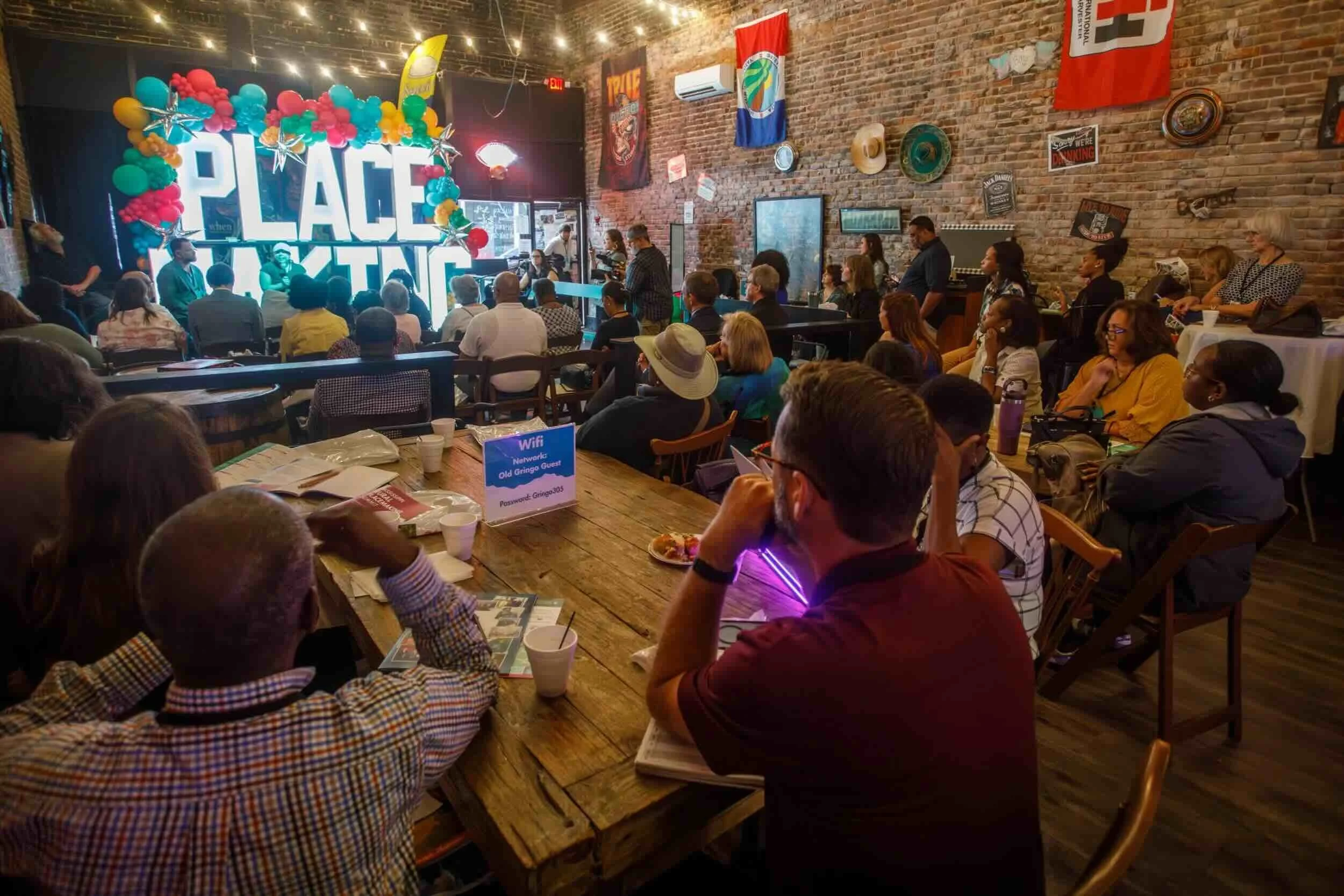 A group of attendees at the Community Foundation for Mississippi's Rural Placemaking Summit. They sit inside a room with large letters that spell out Placemaking.