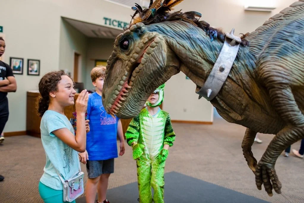 Children looking at a replica of a dinosaur