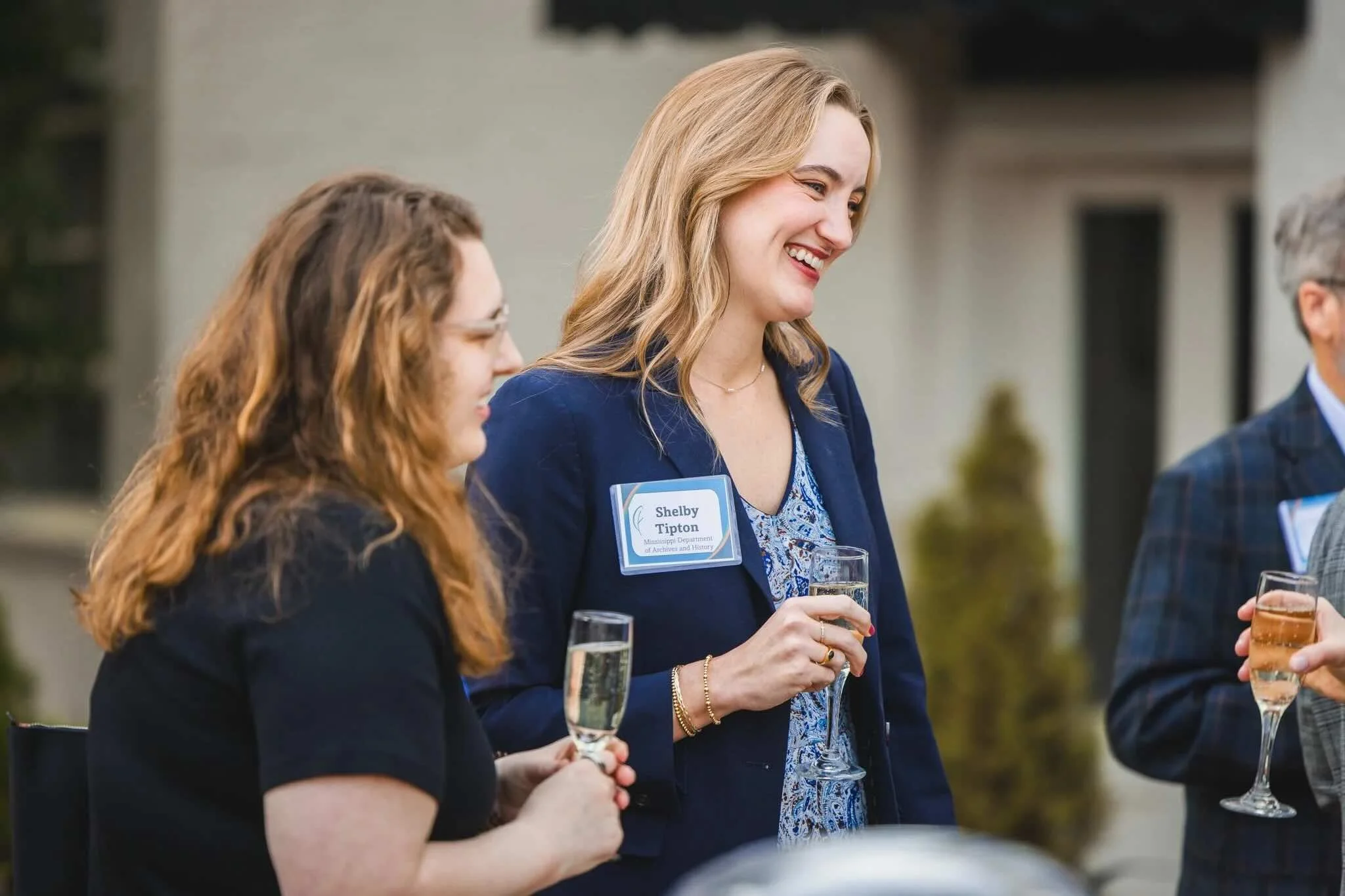 Two women holding drinks speak at CFM's Giving Forward event. 