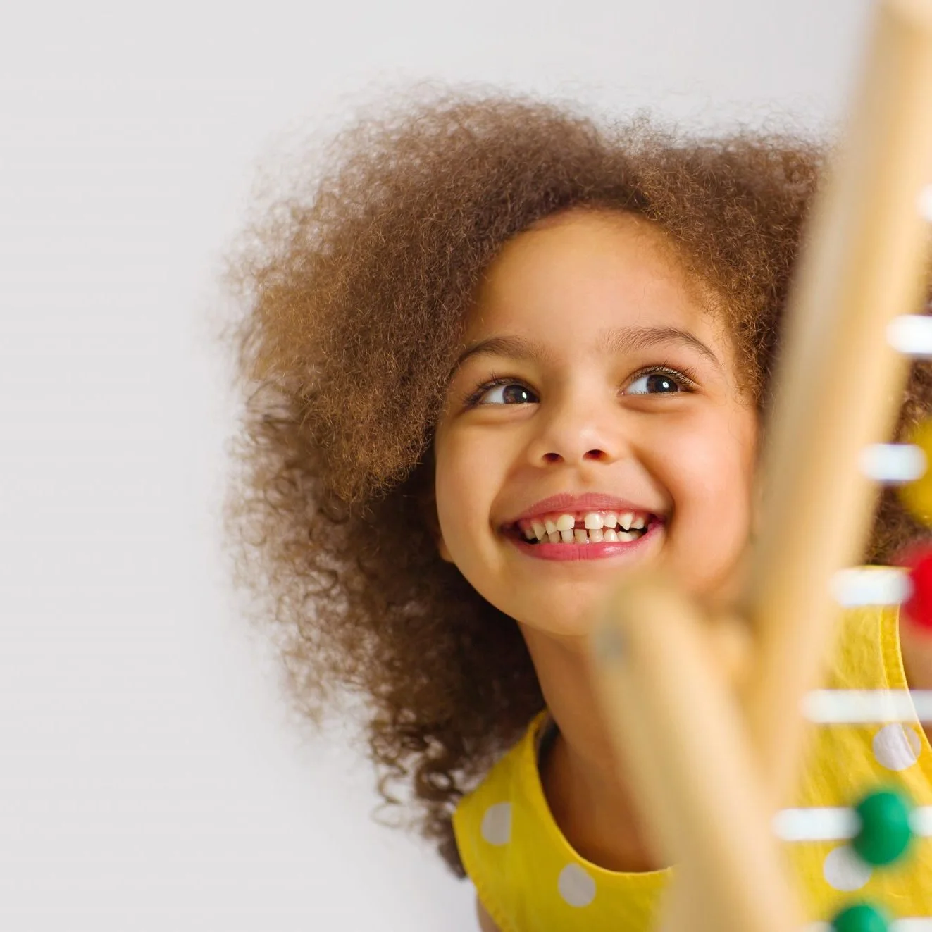 A young girl in a yellow t-shirt smails.