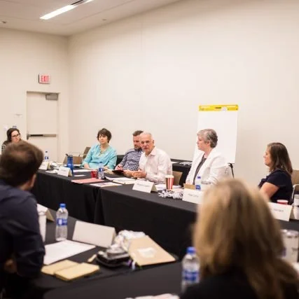 Team members from the Harwood Institute sit around a boardroom table.
