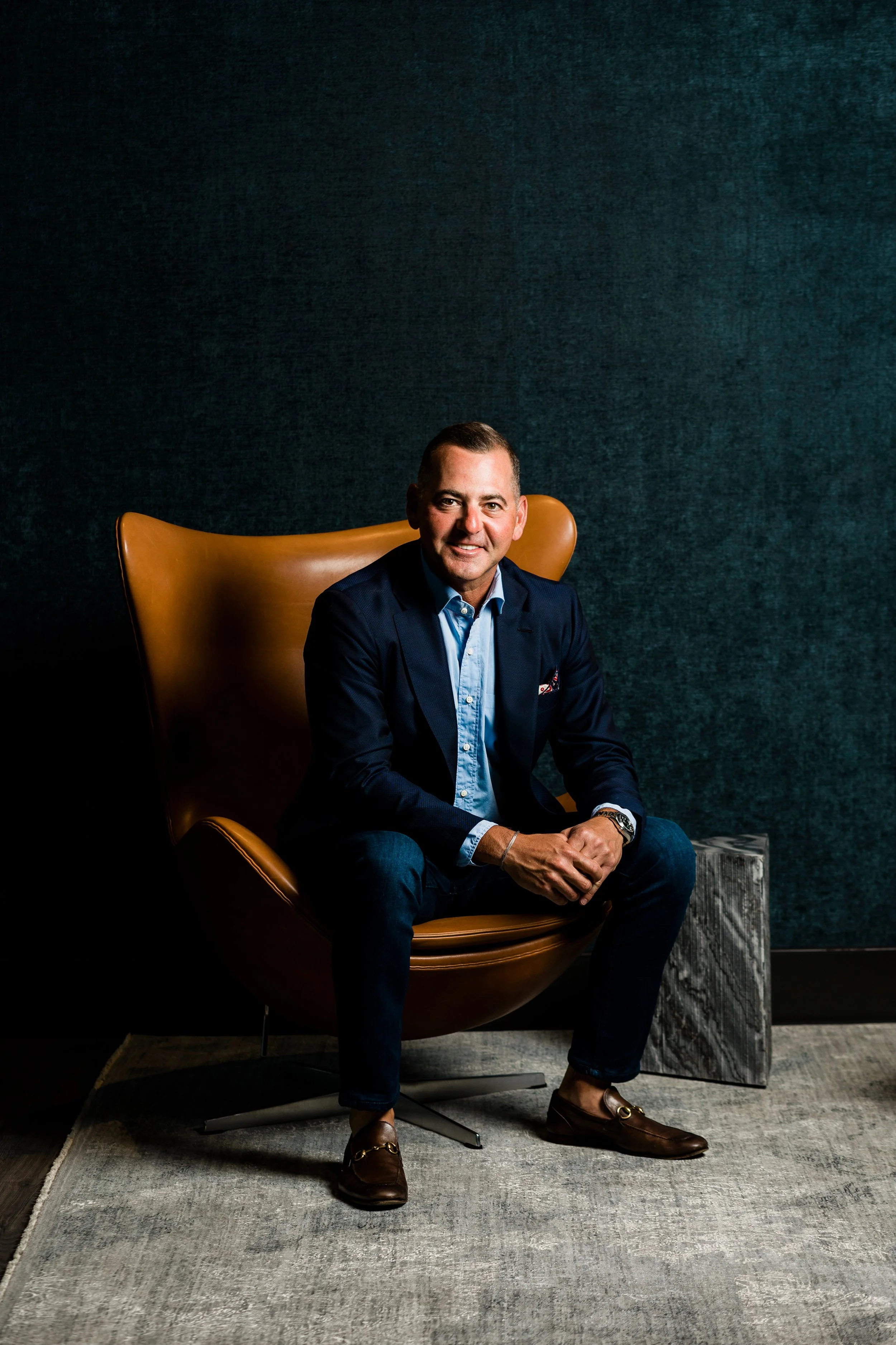environmental portrait of man in wingback leather chair