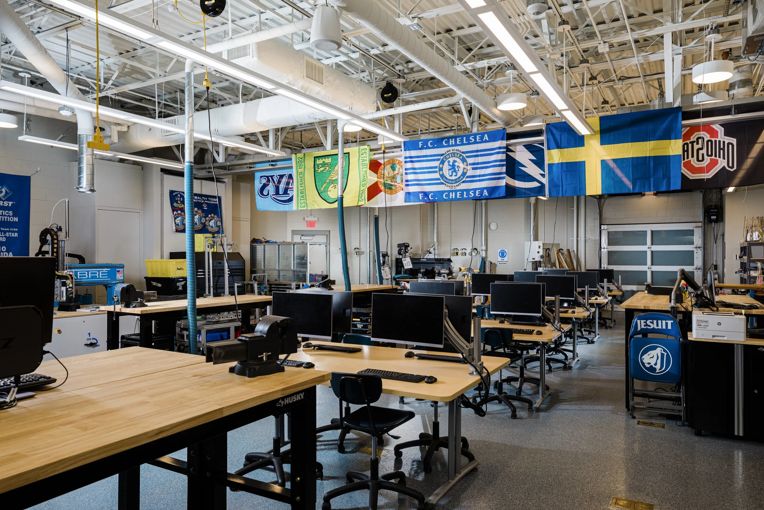 computer tech classroom with flags hanging from the ceiling. Design by Reno Boyd. Jesuit High School.