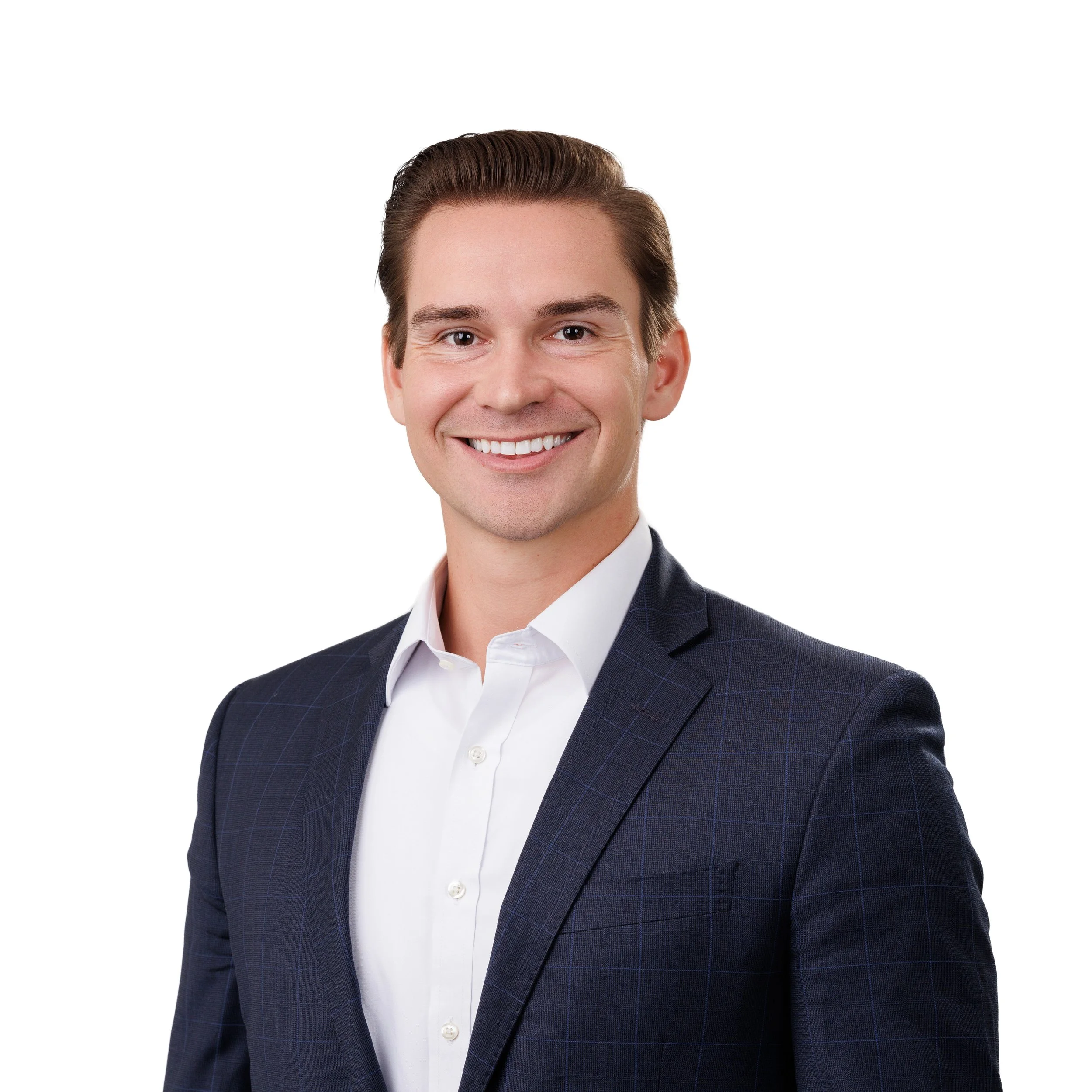 Close-up of a smiling man in a dark checkered blazer and white dress shirt, photographed against a plain white background.