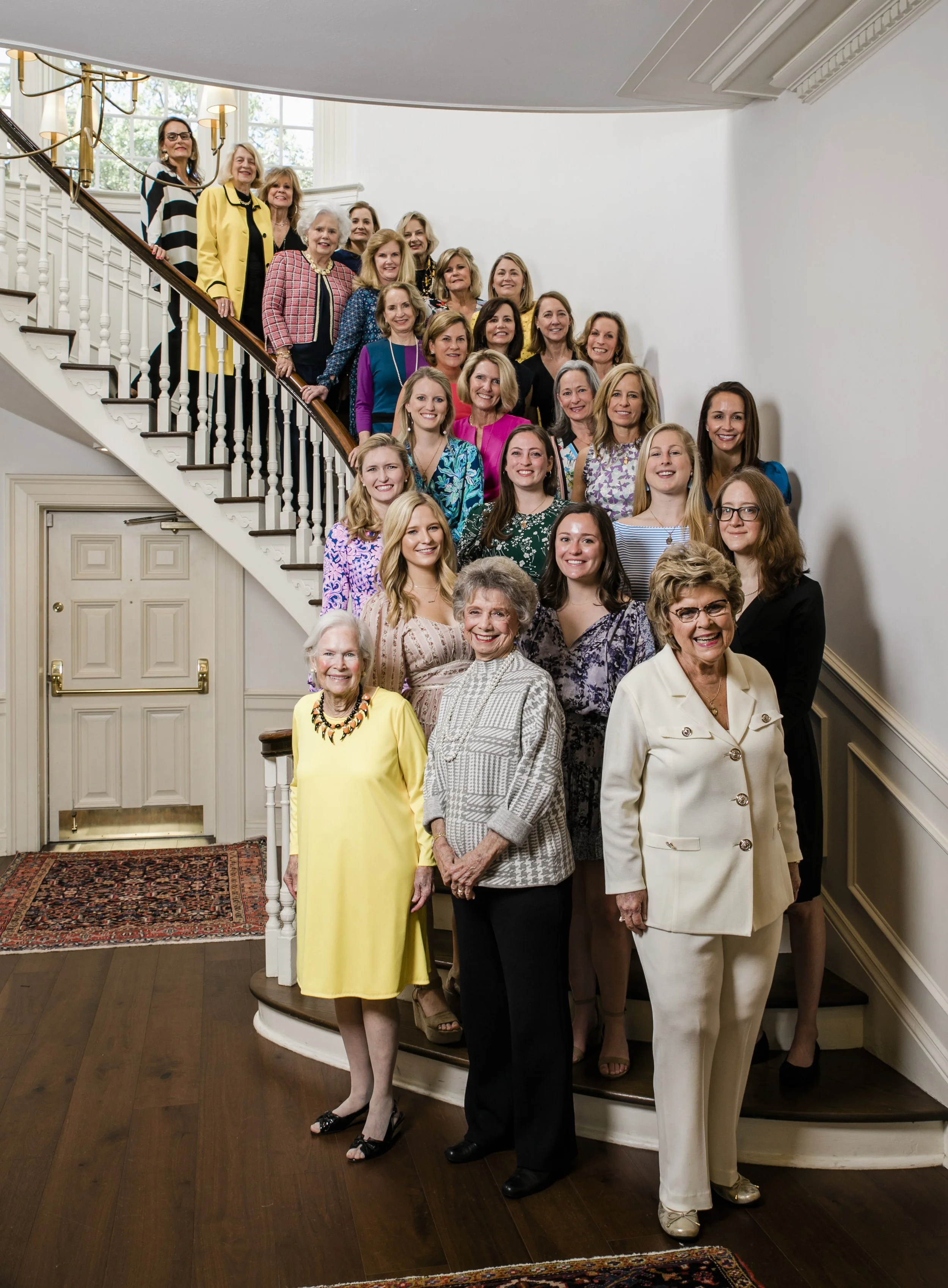 YMKG Queen Gasparilla luncheon at TYCC showing group of past Queens on the lobby staircase.