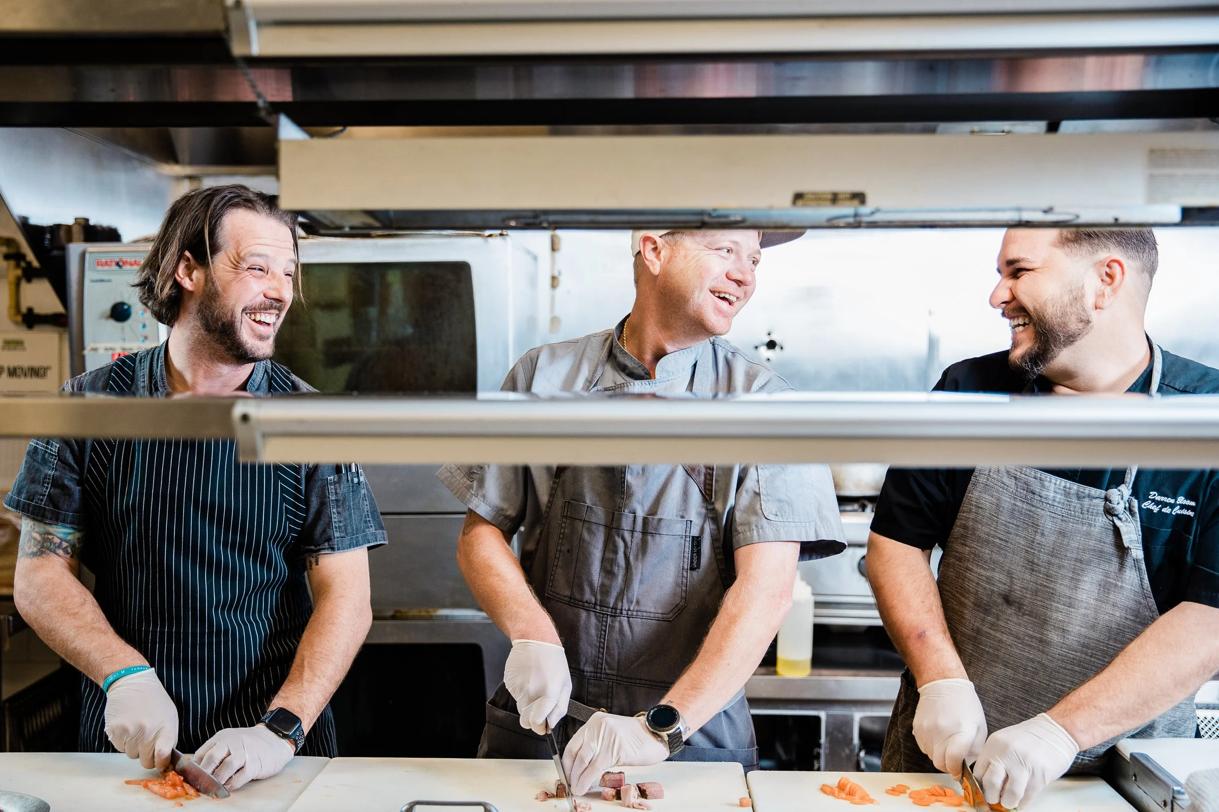 Three Birchwood chefs working on the line laughing with each other