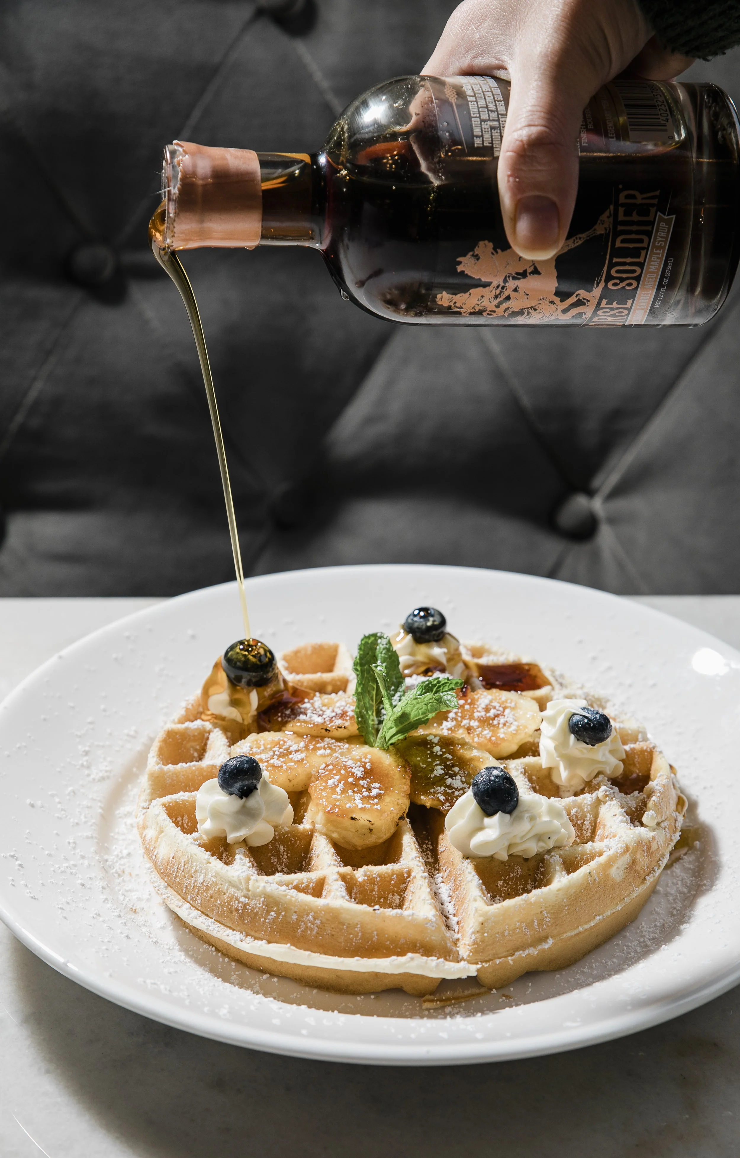 Urban Stillhouse Buffalo Soldier maple syrup being poured onto a waffle breakfast