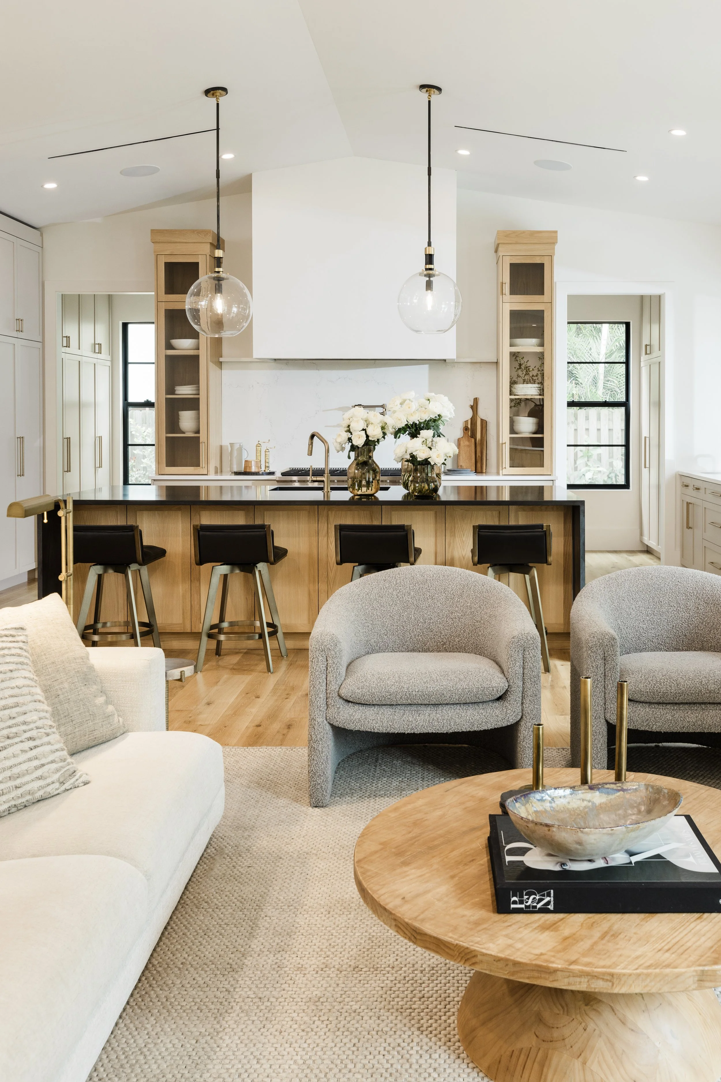 Living room with white sofa, gray armchair, wooden coffee table, and beige wall-to-wall carpet.