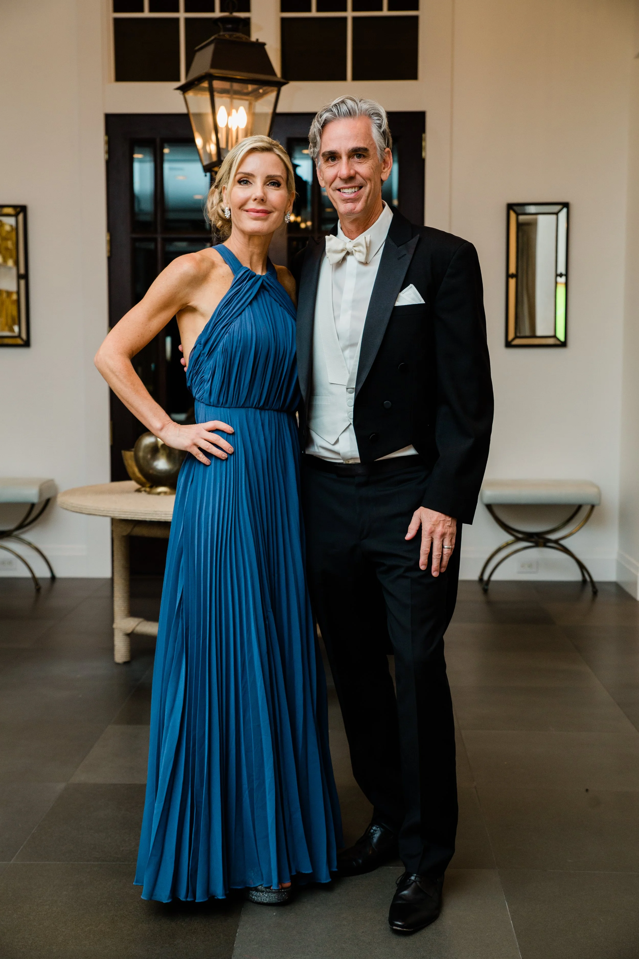 Woman in a long blue dress, man in a tux and tails