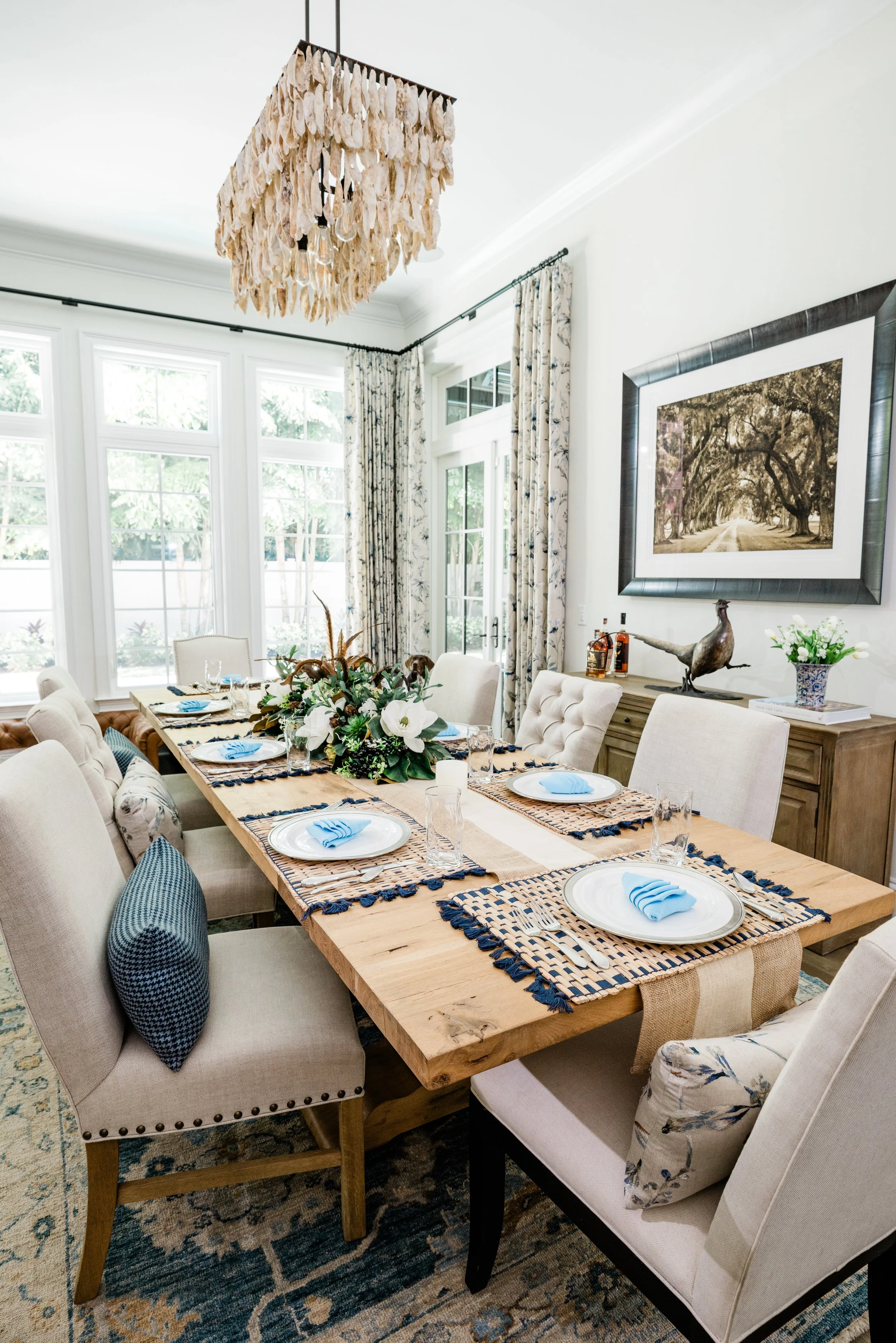 Interiors photo of a dining room table set for a party. Coastal-inspired decor by J. Banks Design.