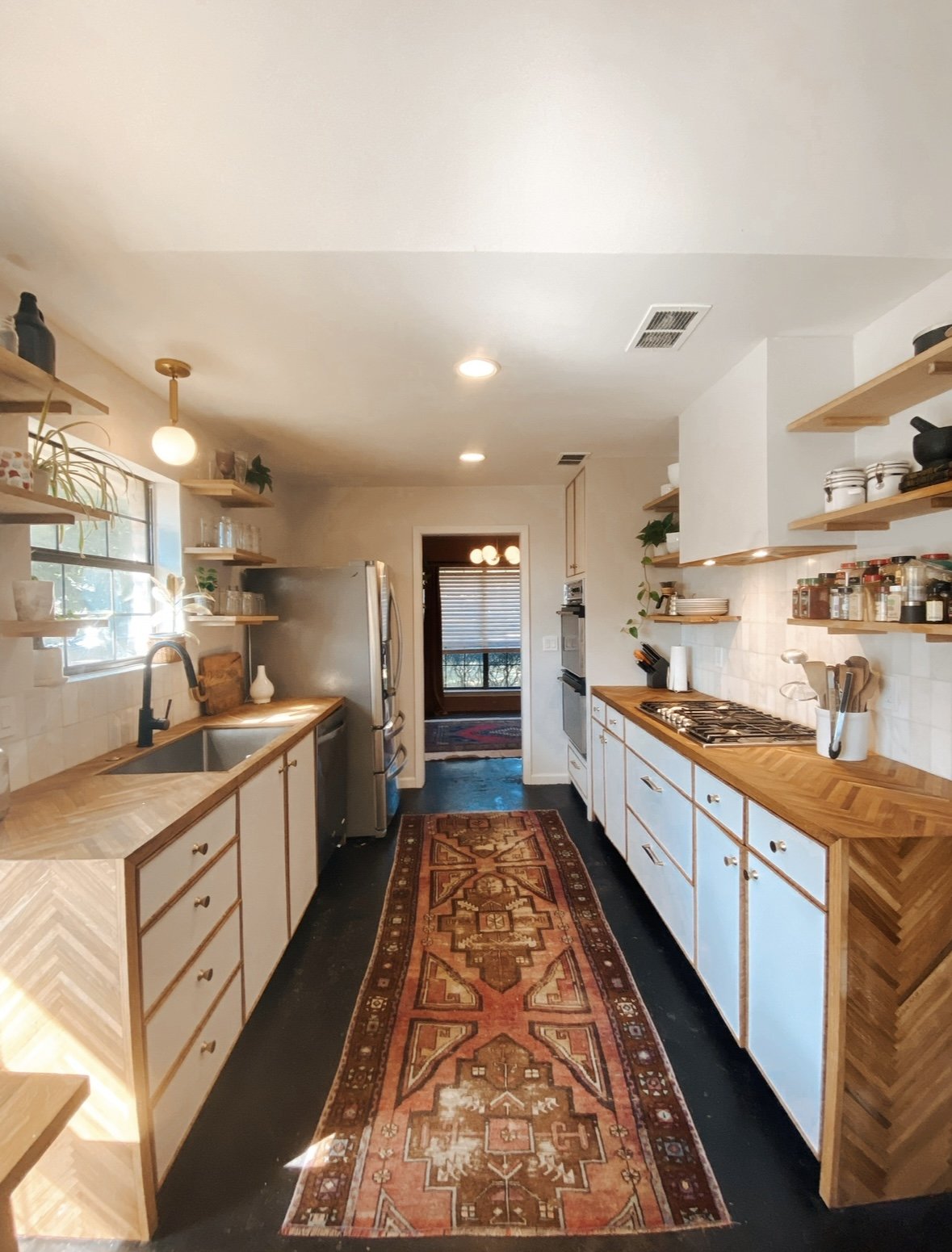 Custom made herringbone butcher block countertops with custom made vent hood and floating shelves by Opal & Oak