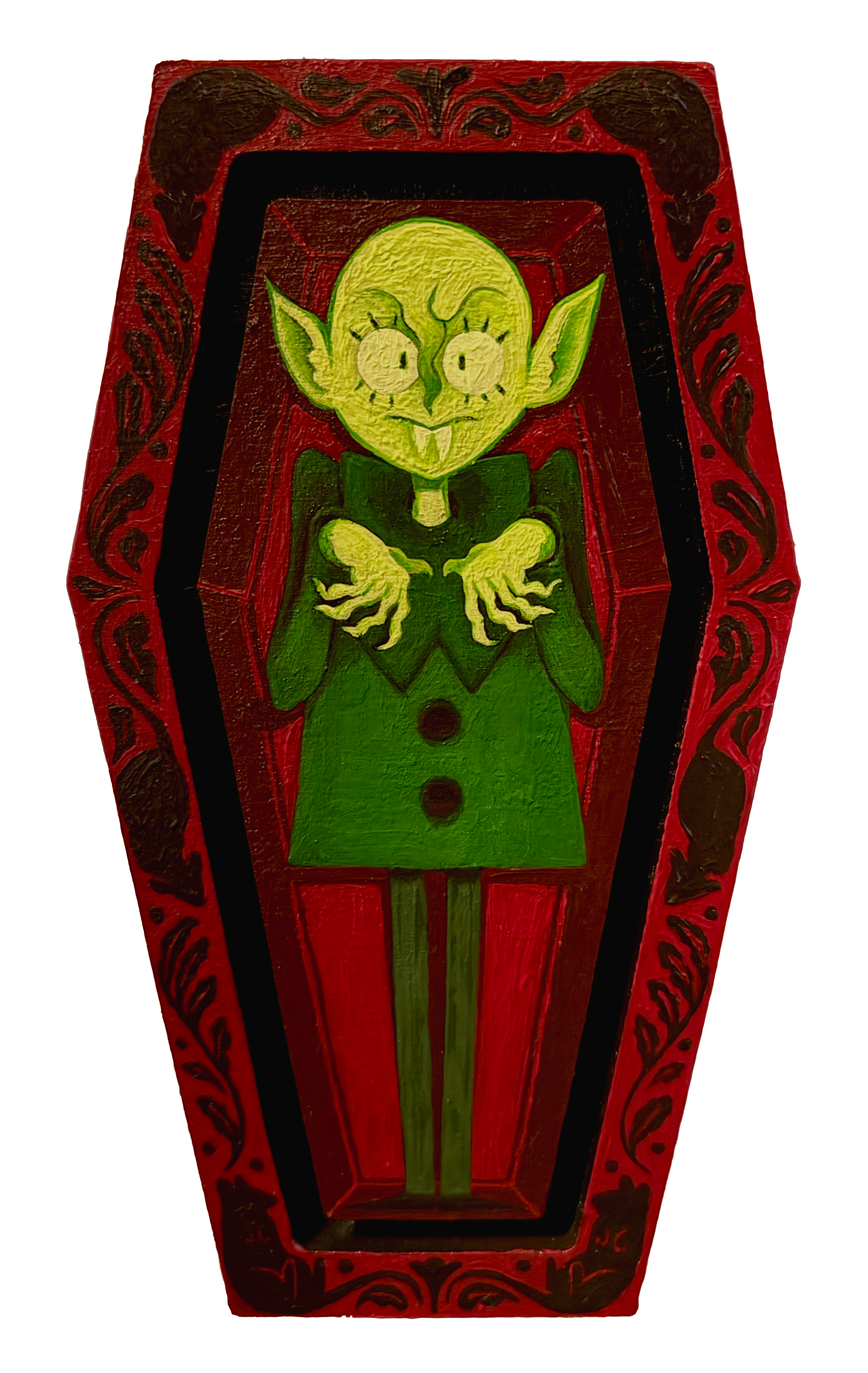 Colorful Halloween decoration featuring a painted wooden coffin with a cartoonish green vampire face with pointy ears, fangs, and a mischievous grin.