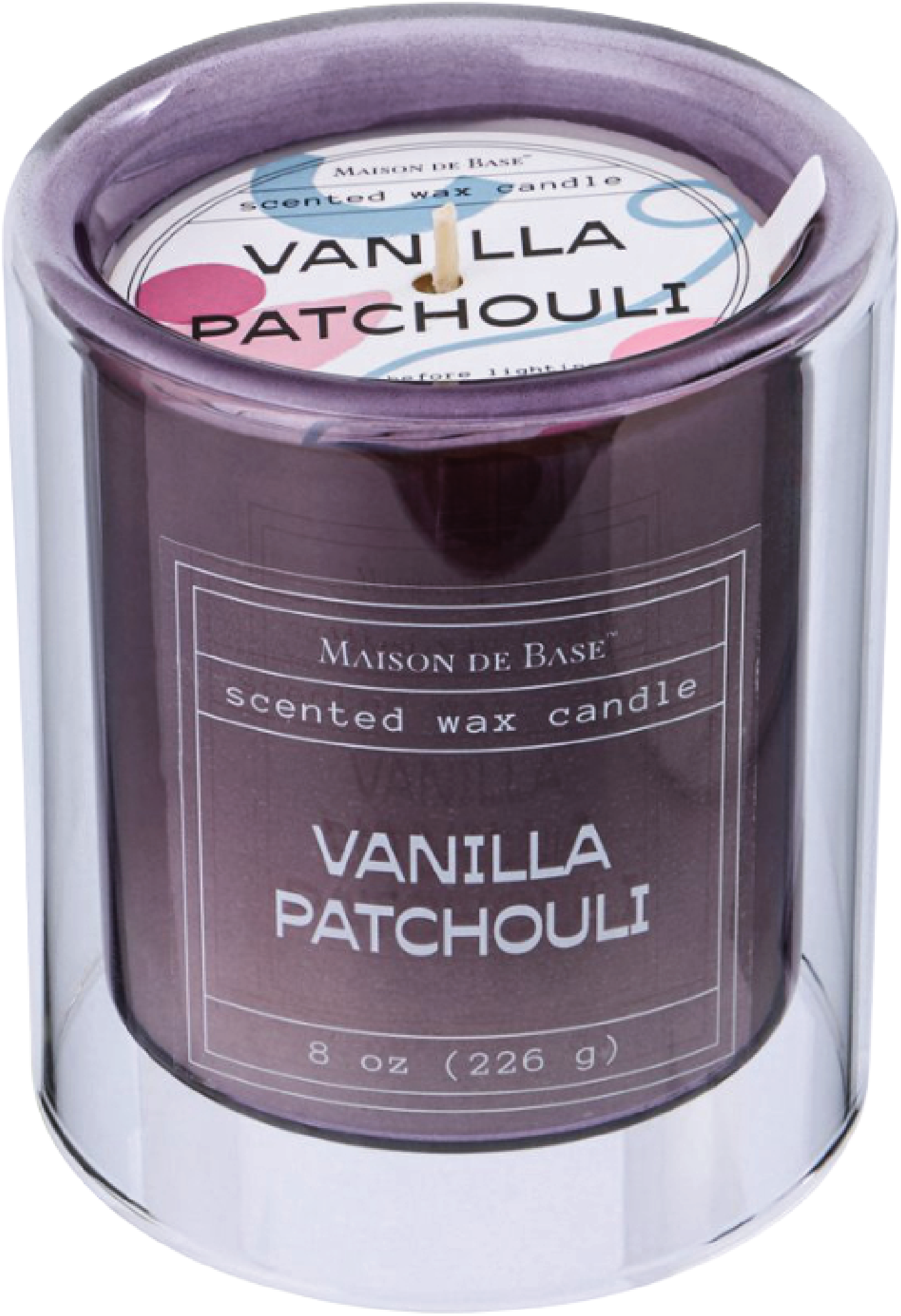 A scented wax candle in a purple glass jar labeled 'Vanilla Patchouli' with a white lid and a wick in the center.