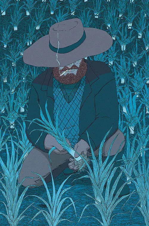 A man with a beard wearing a hat and dark clothing, kneeling in a field of tall blue plants, holding some plants in his hands.