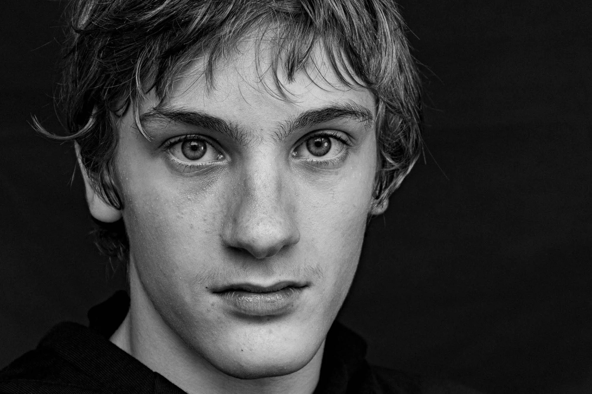 Ritratto in bianco e nero di un giovane con capelli corti e occhi chiari