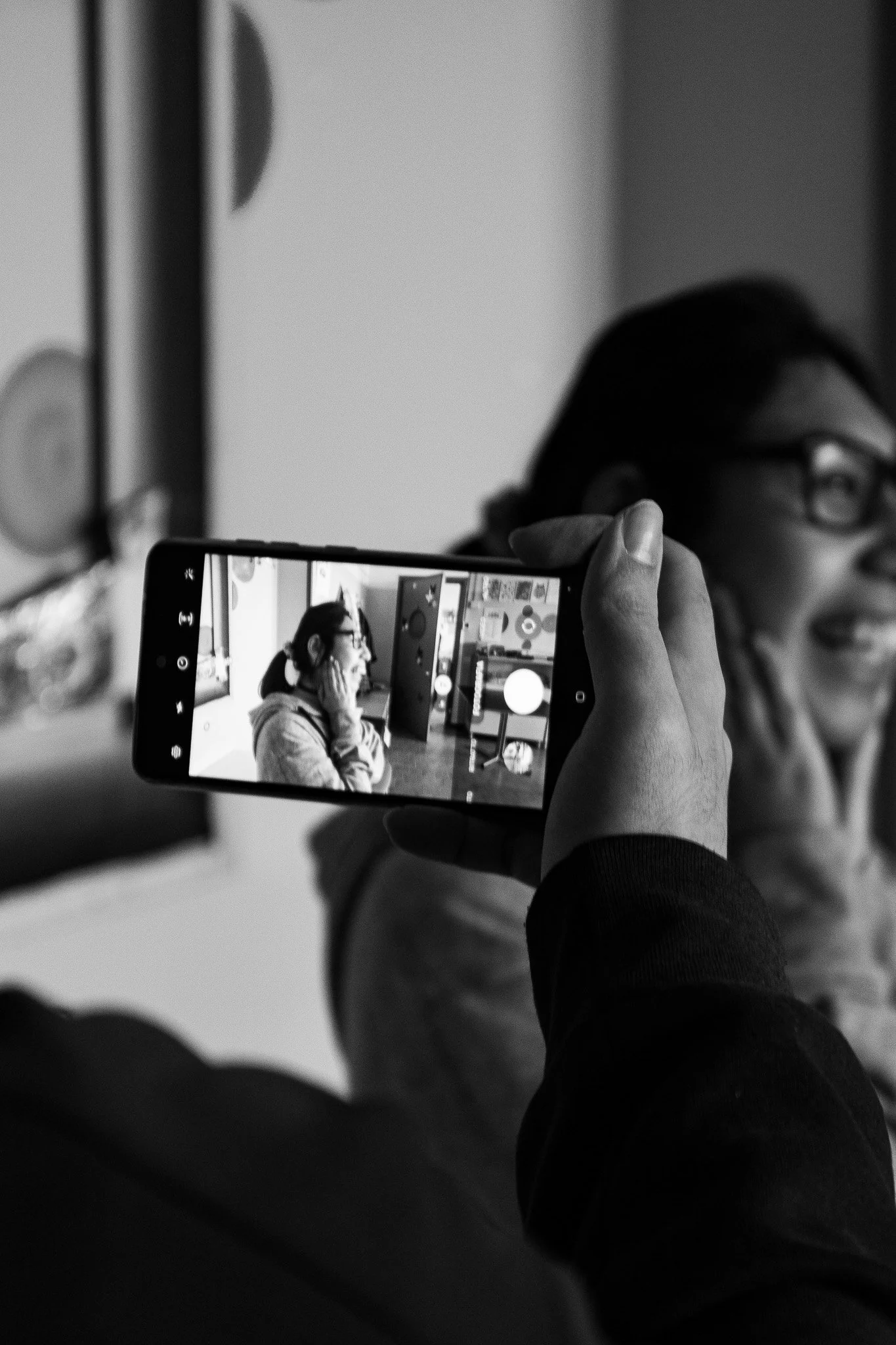 Persona che scatta una foto ad una ragazza sorridente con uno smartphone