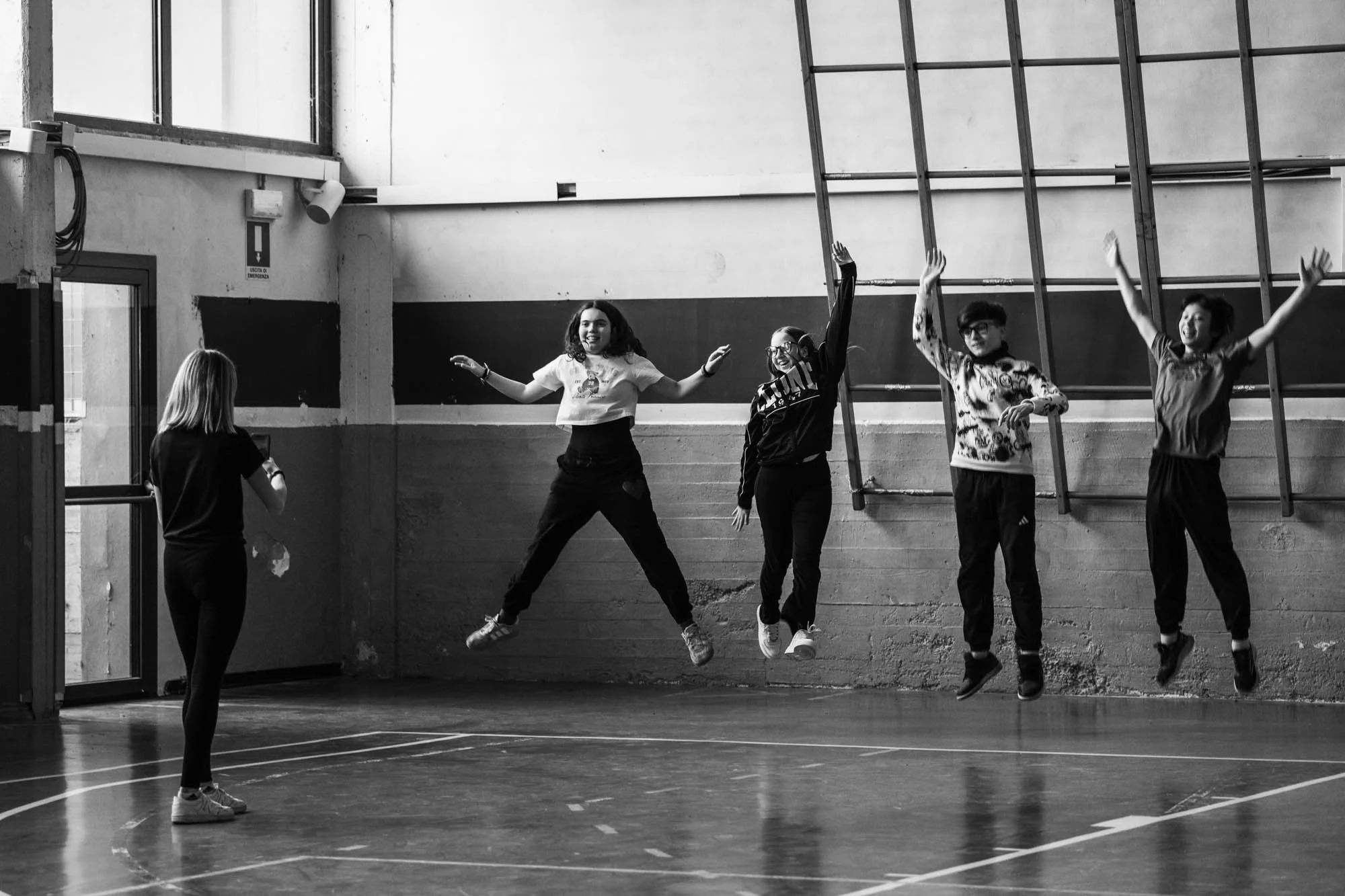 Ragazze e ragazzi che giocano e saltano in palestra