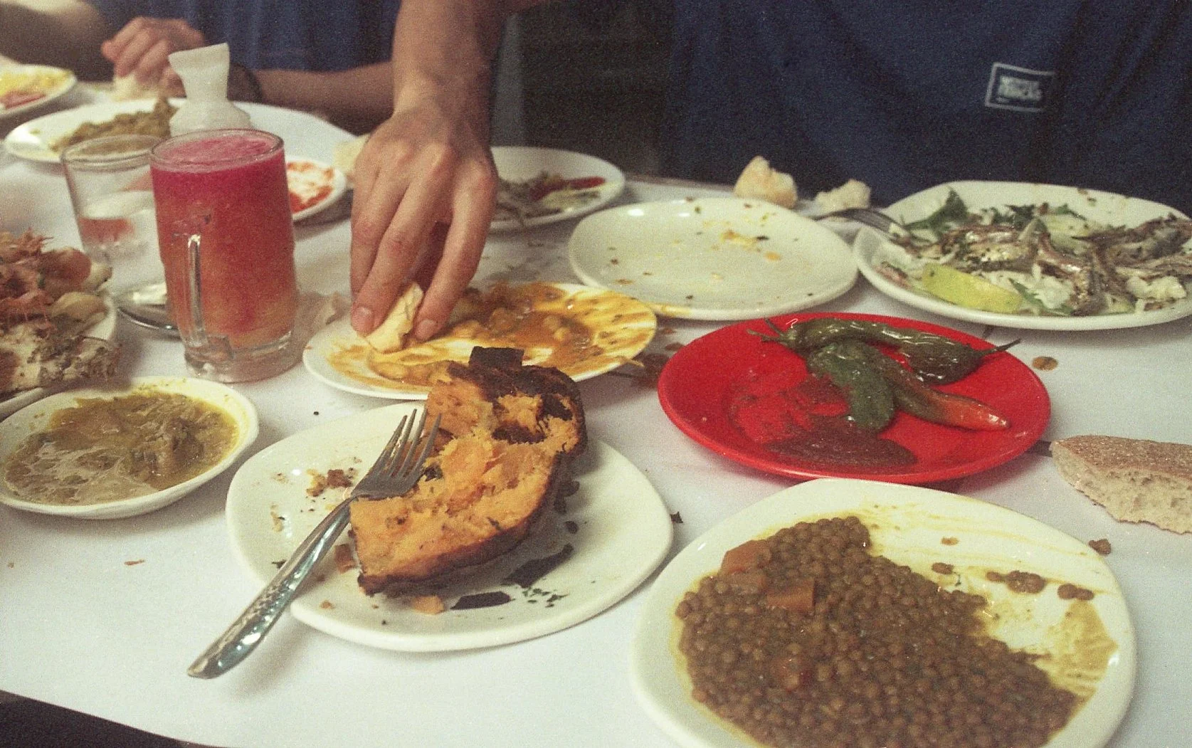 Table avec divers plats de nourriture africaine, y compris du riz, des légumes, de la viande et des sauces.