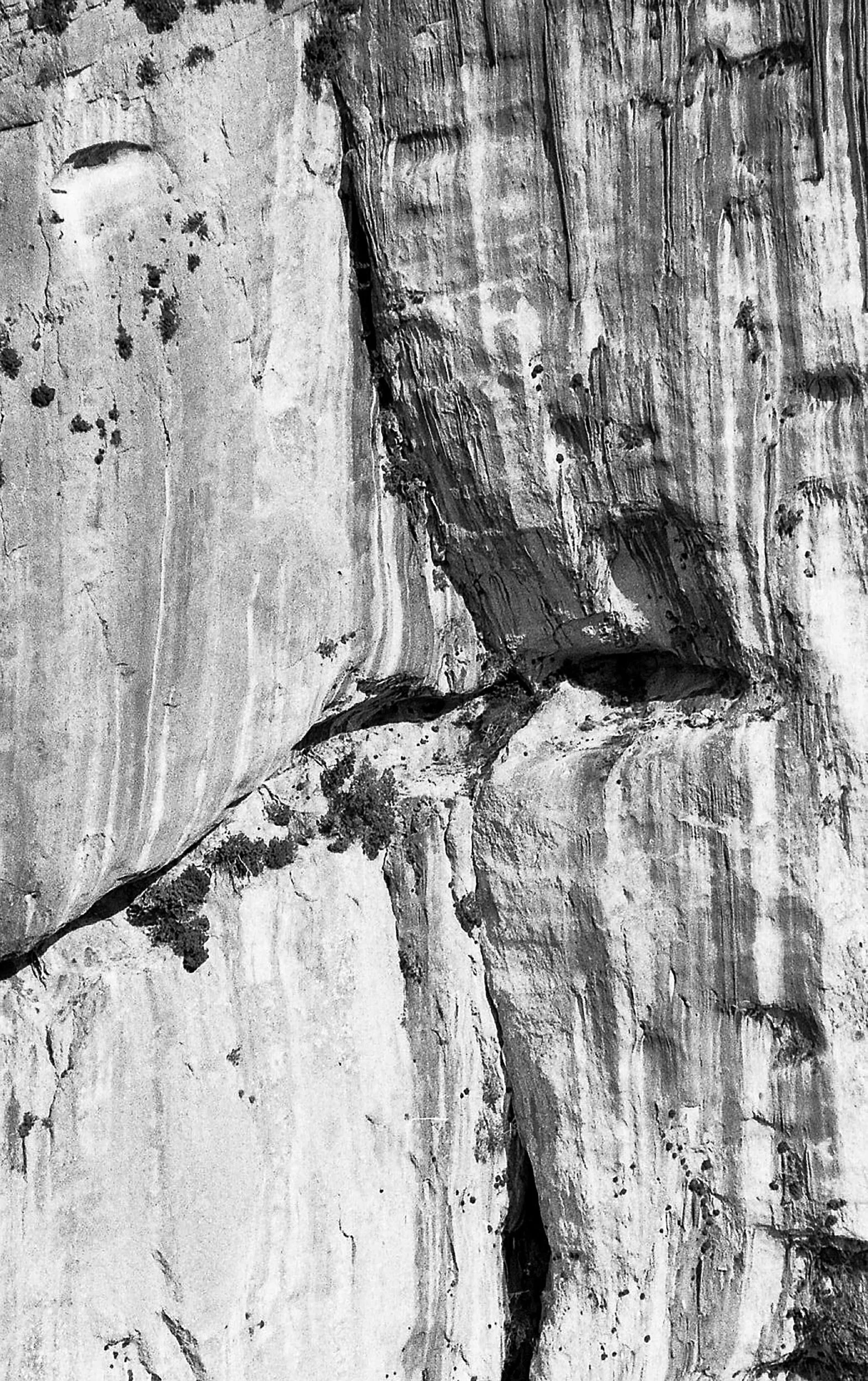 Une photo en noir et blanc d'une formation rocheuse, ressemblant à un visage ou une silhouette façonnée par la nature.