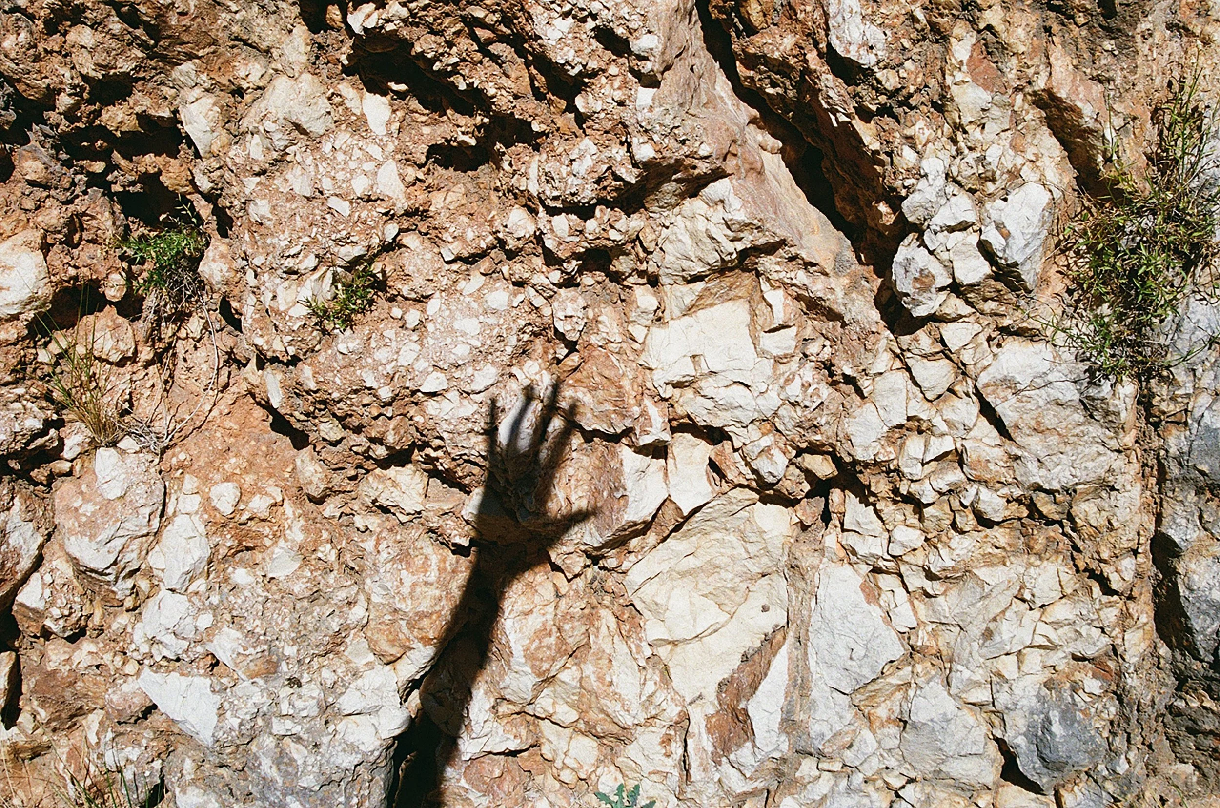Main de représentant une sculpture ou un objet sur une surface rocheuse.