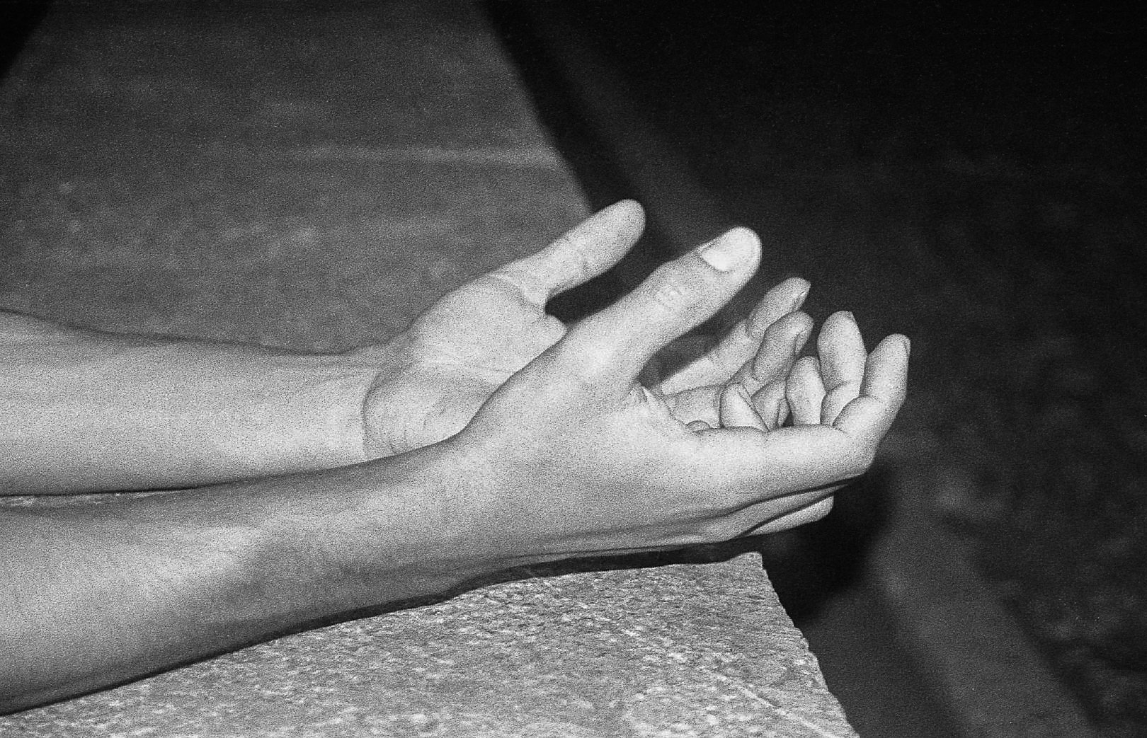 Mains humaines ouvertes, l'une placée au-dessus de l'autre, dans une position de prière ou de méditation.