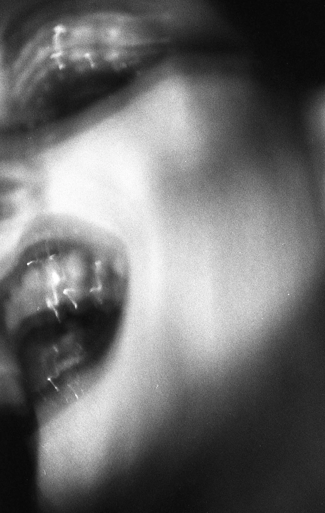 Photo en noir et blanc d'une personne portant des boucles d'oreilles, avec un visage partiellement visible, mettant en valeur l'oreille et la moitié du visage.