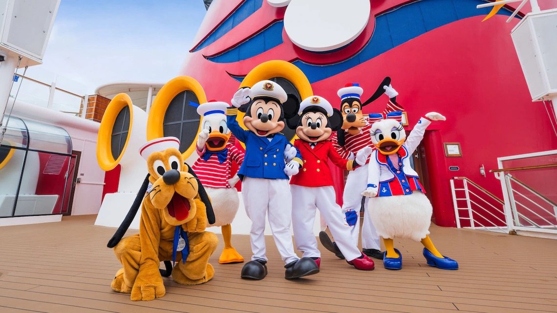 Costumed characters including Mickey Mouse, Minnie Mouse, Pluto, Daisy Duck, Donald Duck, and Goofy aboard a cruise ship deck.
