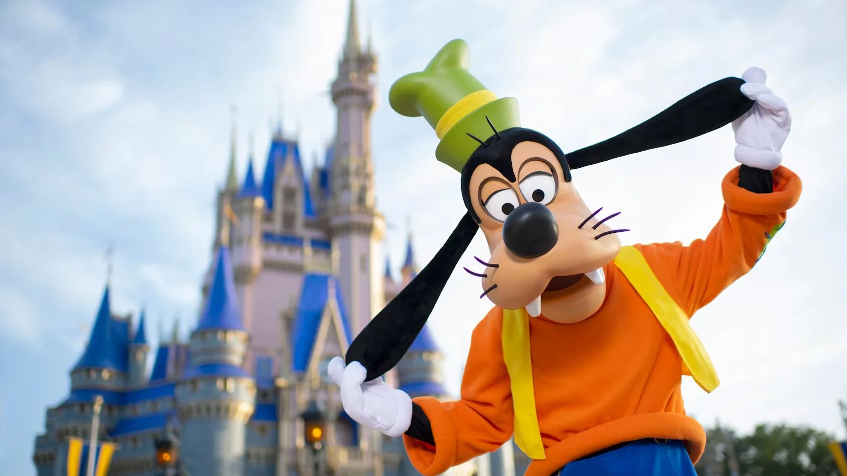 Goofy mascot dressed as a chef at Disney World with Cinderella Castle in the background.