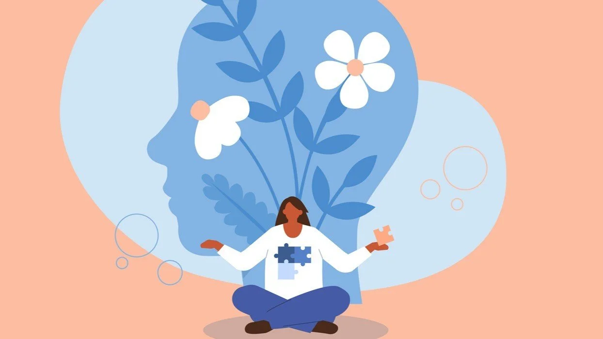 Illustration of a woman sitting cross-legged with a puzzle piece in her hand, in front of a large silhouette of a face with flowers and leaves in it, representing mental wellness.