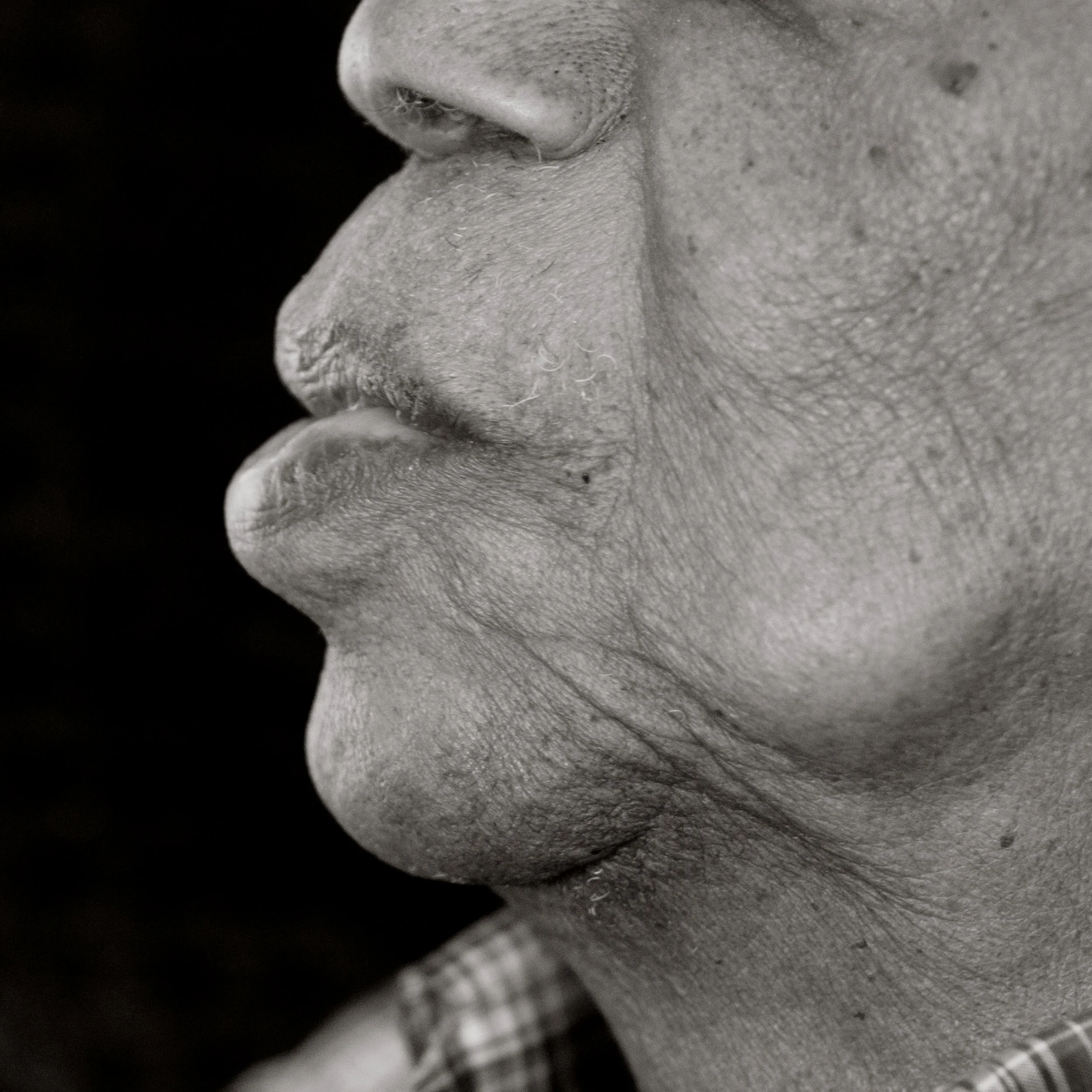 Close-up of a person's face showing the nose, mouth, and chin in black and white.
