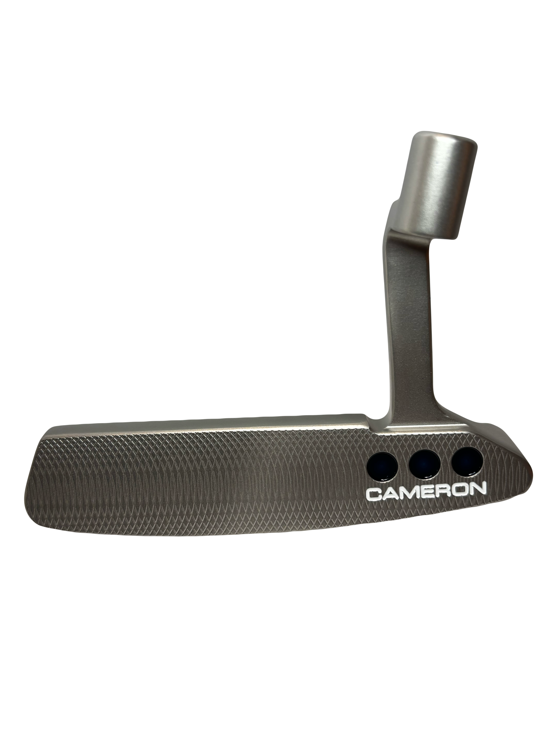 A close-up view of a metallic golf putter with a textured face, the brand name 'Cameron' printed on it, and a vertical shaft attached at the top.