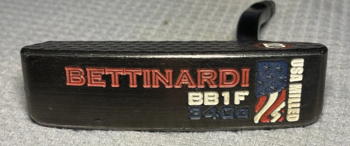A golf club with engravings and US flag design, including the name 'BETTINARDI,' model 'BBTF 340C,' and patriotic graphics.