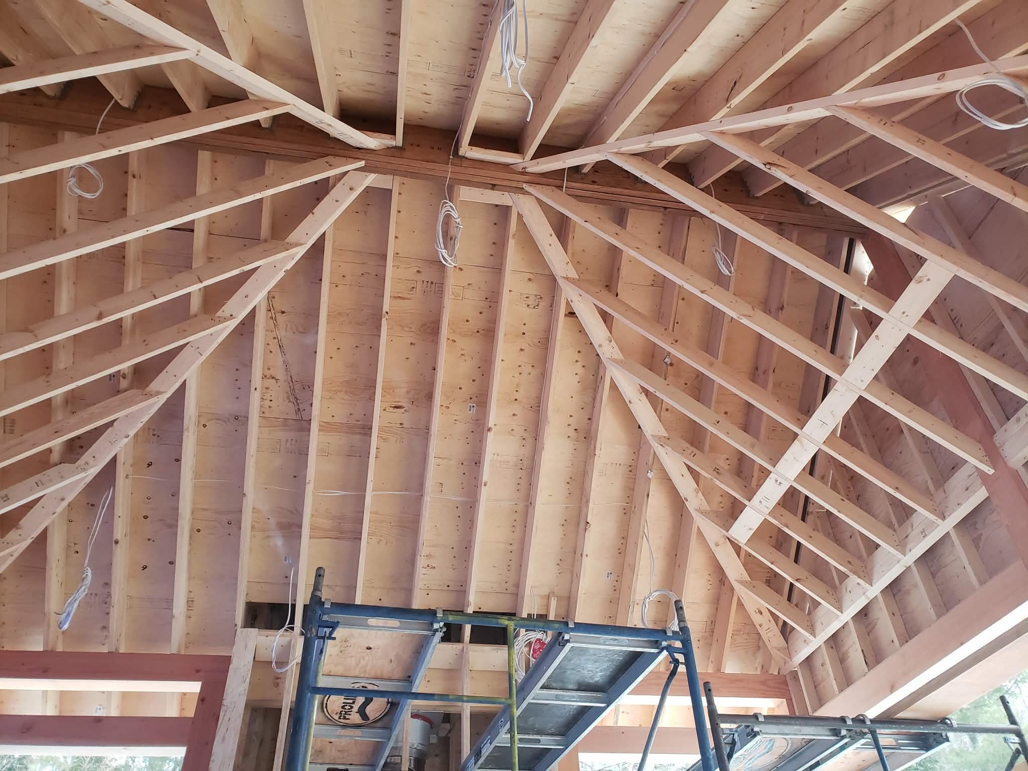 Wooden ceiling framework and scaffolding inside a building under construction.