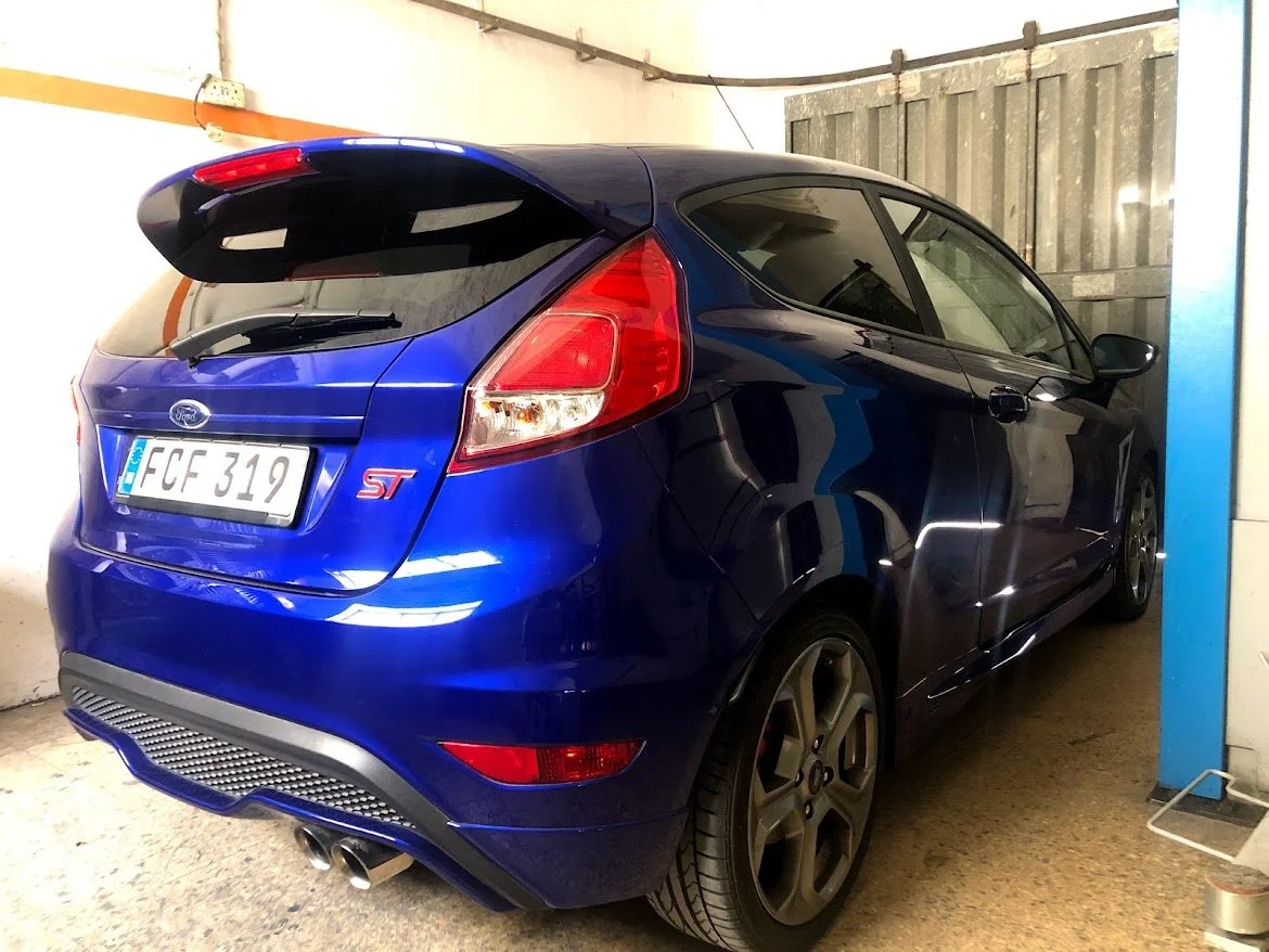 Blue Ford Focus ST hatchback parked in a garage.