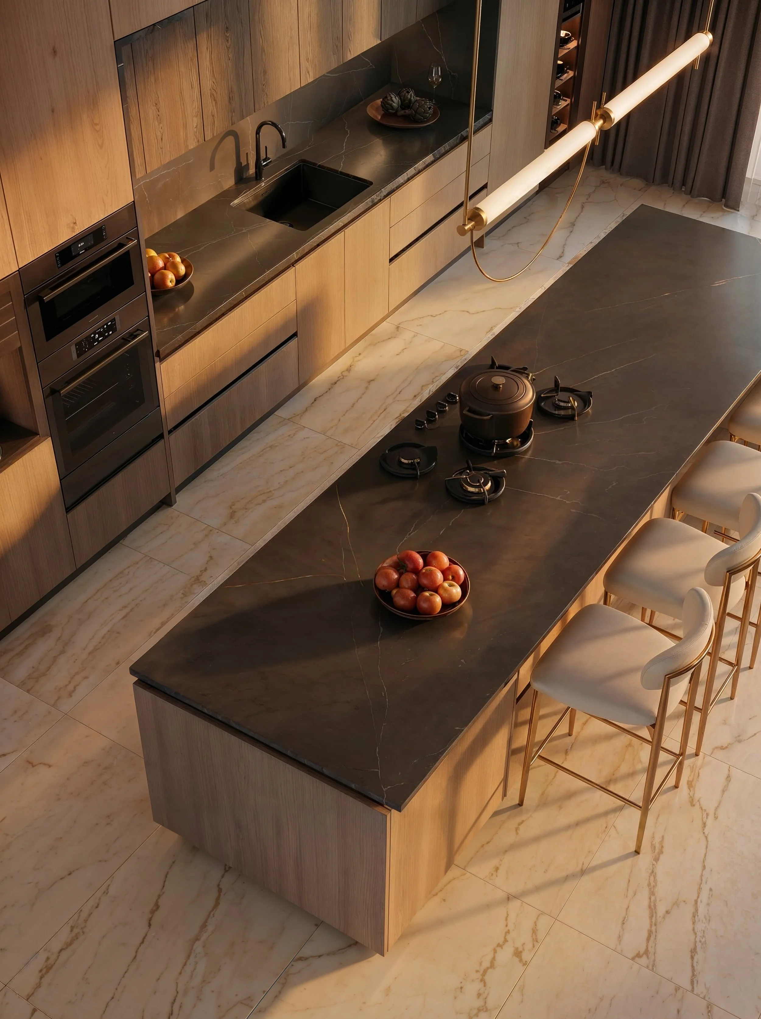 A modern kitchen with a black marble countertop, wooden cabinets, a black sink, and a cooktop with a kettle. There are chairs along the side of a black marble island with a bowl of apples. A hanging light fixture is above the island, and dark curtains are in the background.